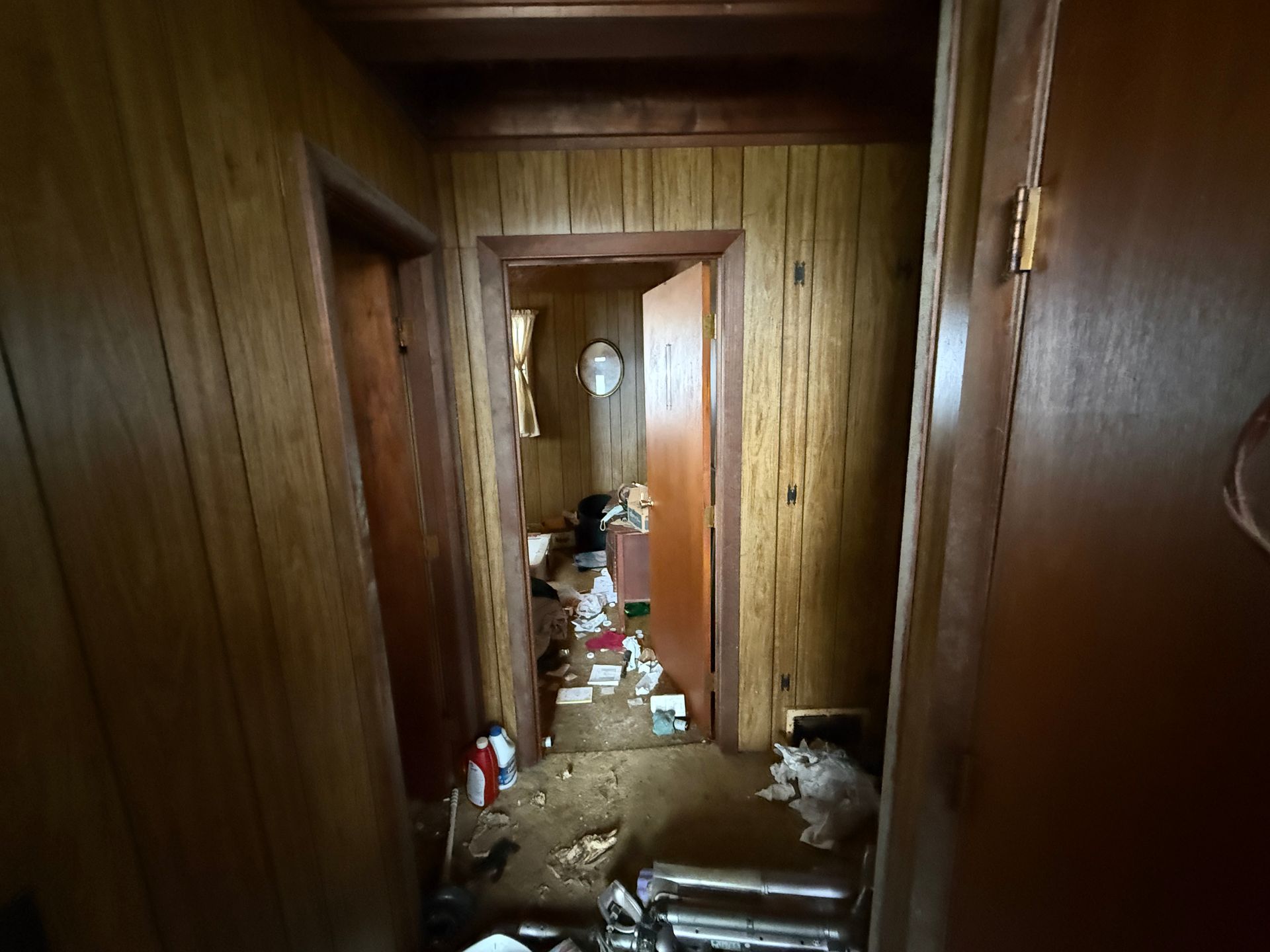 Hallway with wood paneling, open door.