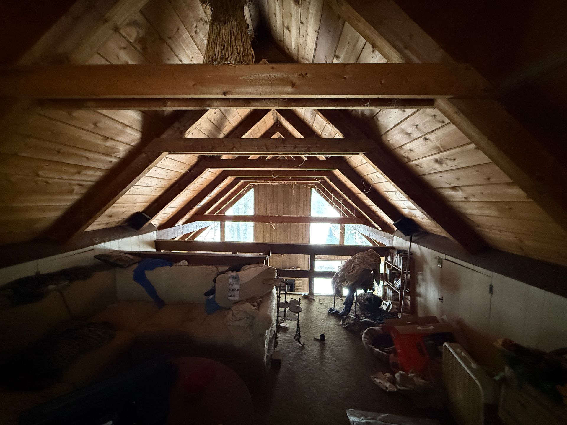 Wooden attic space with exposed beams.