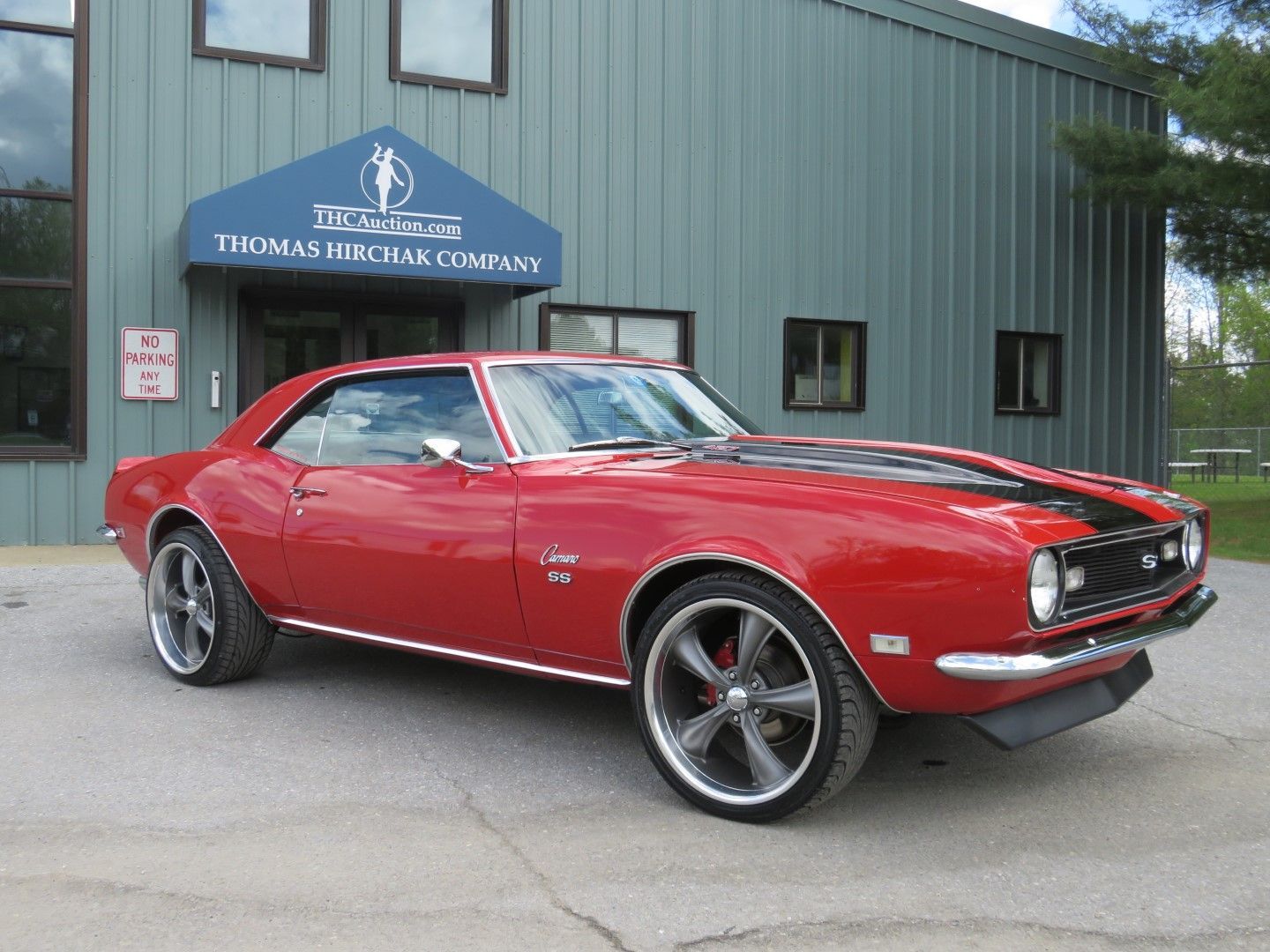 Red 1967 Chevy Camaro SS parked outside the Thomas Hirchak Company building.