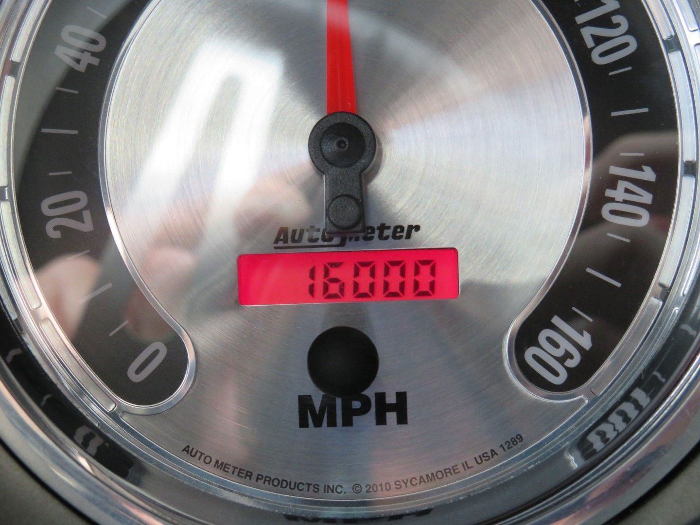 Silver speedometer showing 16,000 MPH, with a red needle. 