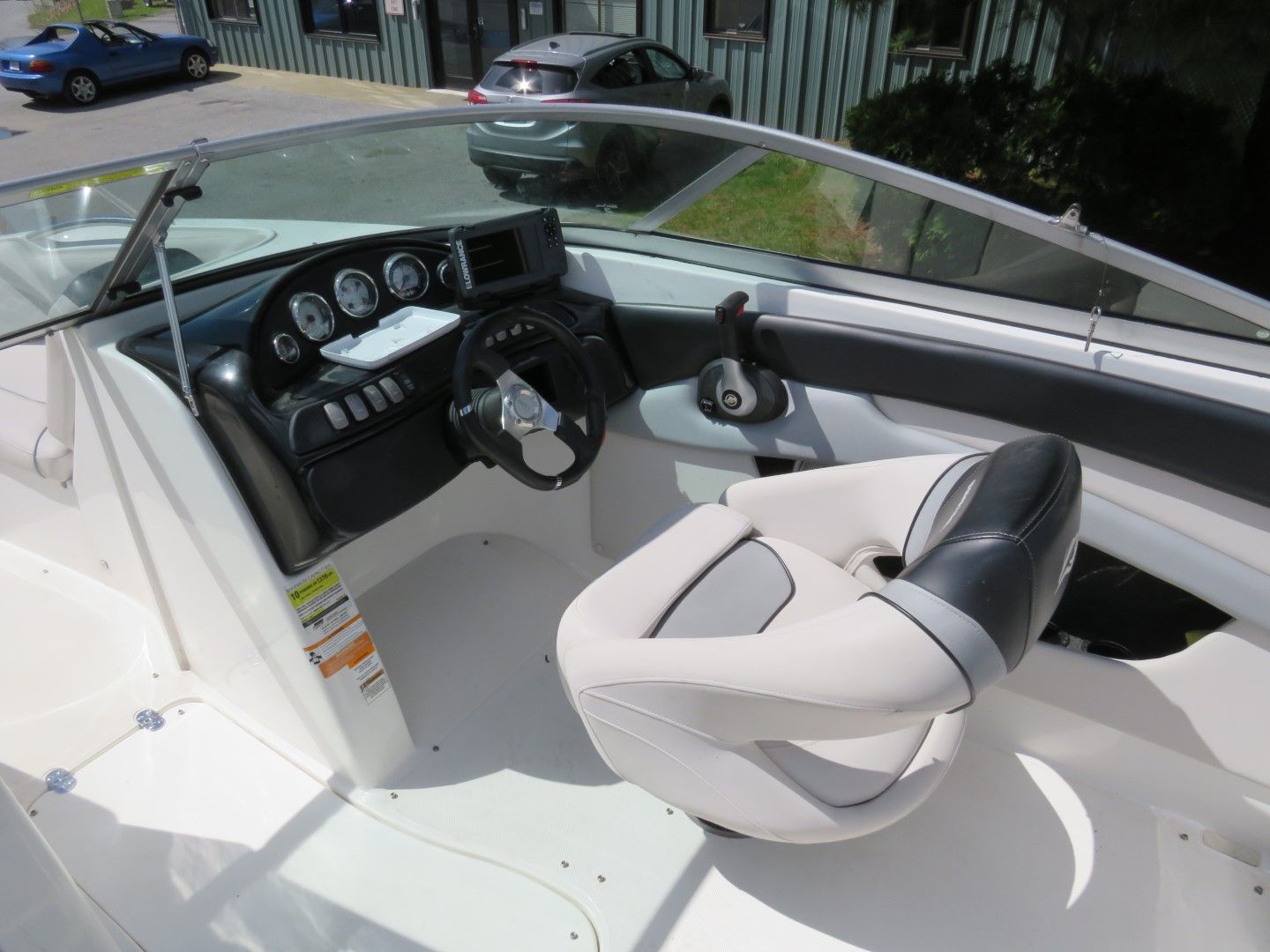 Boat interior with a steering wheel, gauges, and a captain's chair.