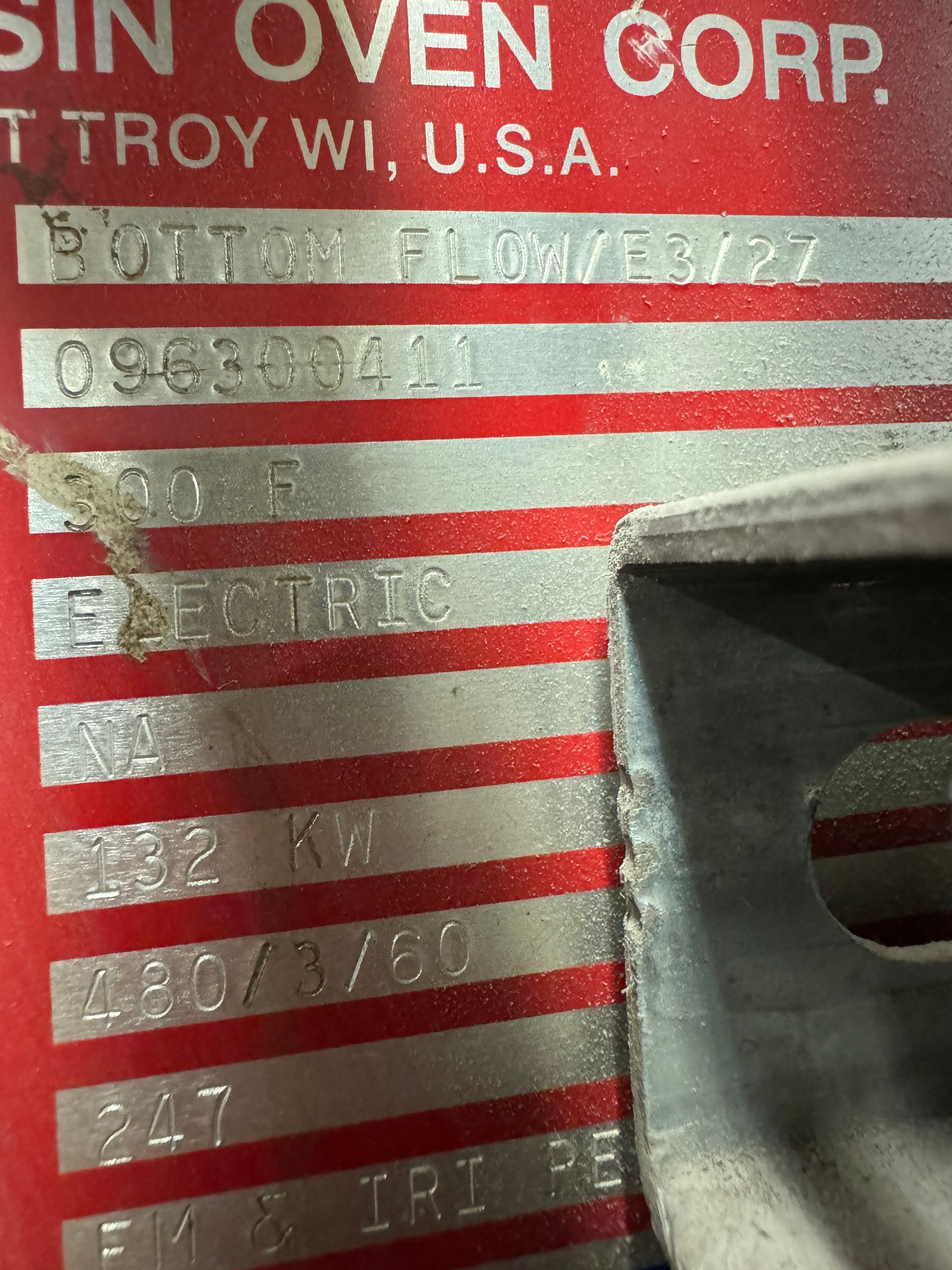 Close-up of a red metal tag with stamped text, information for a 