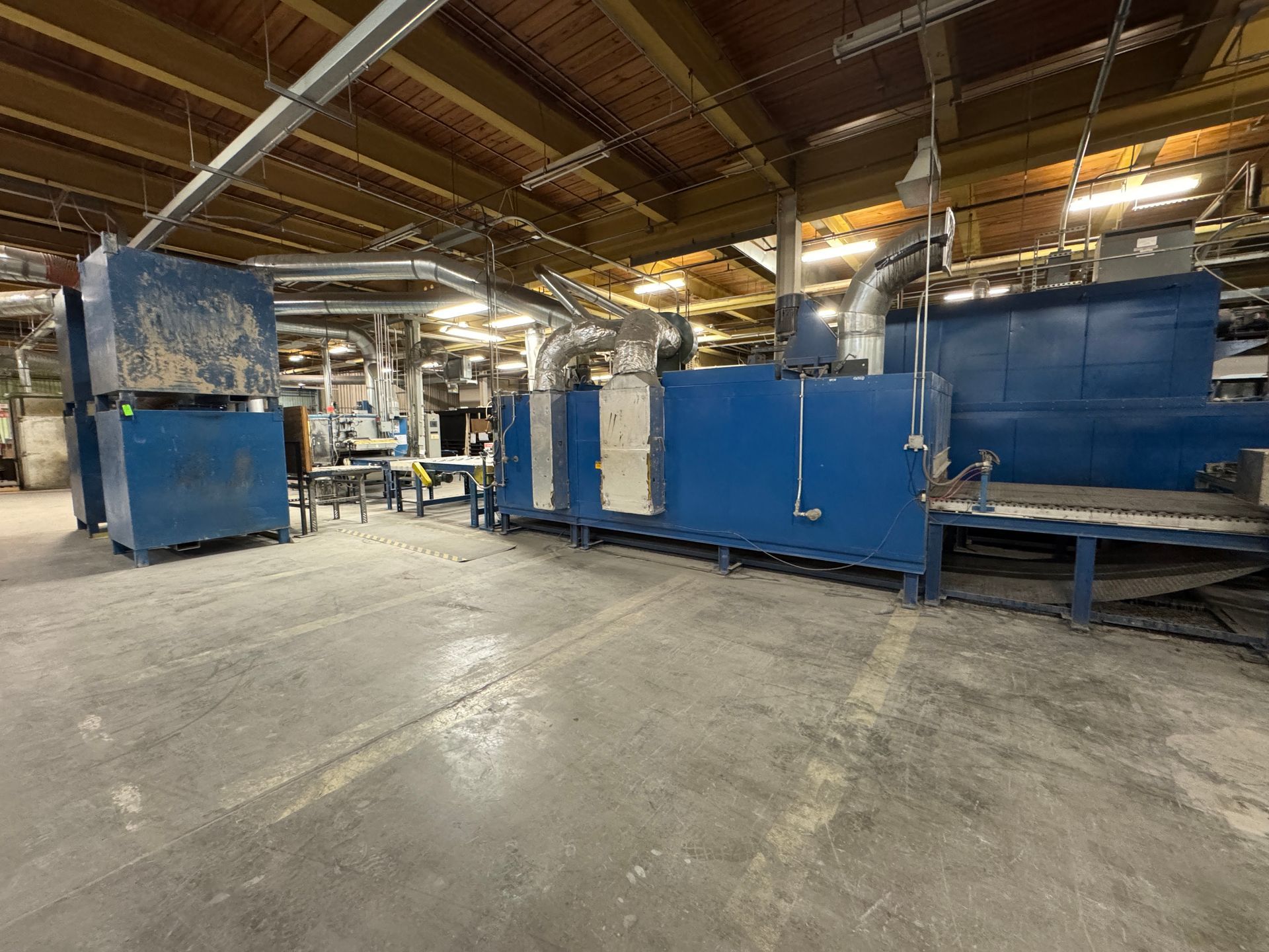 Blue industrial machinery in a large warehouse.