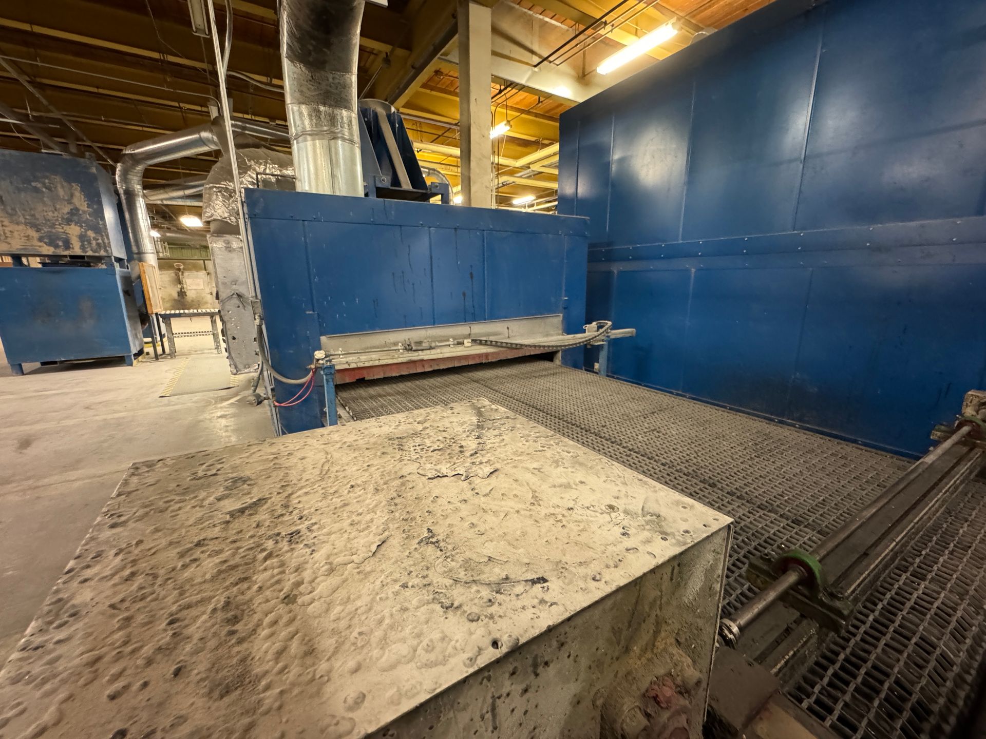 Blue industrial machine with conveyor belt.