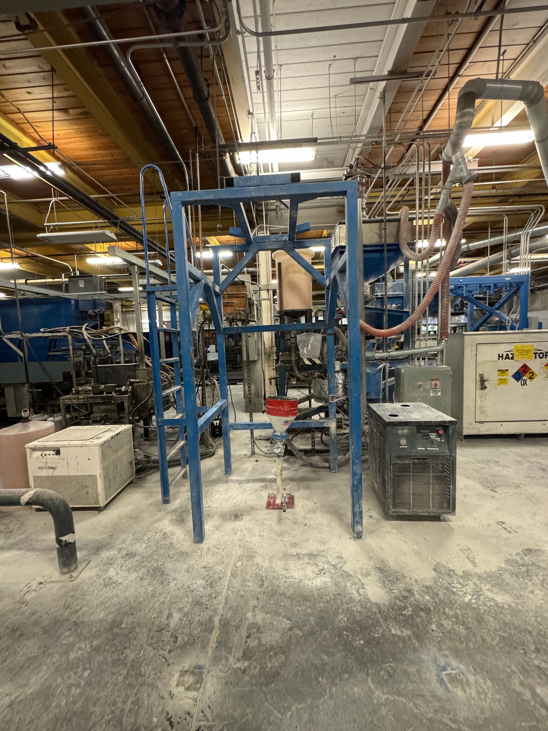 Blue industrial frame in a factory with equipment.