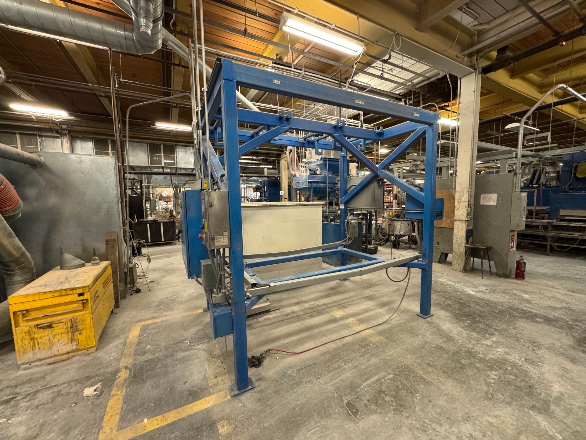 Blue industrial machine in a factory setting.