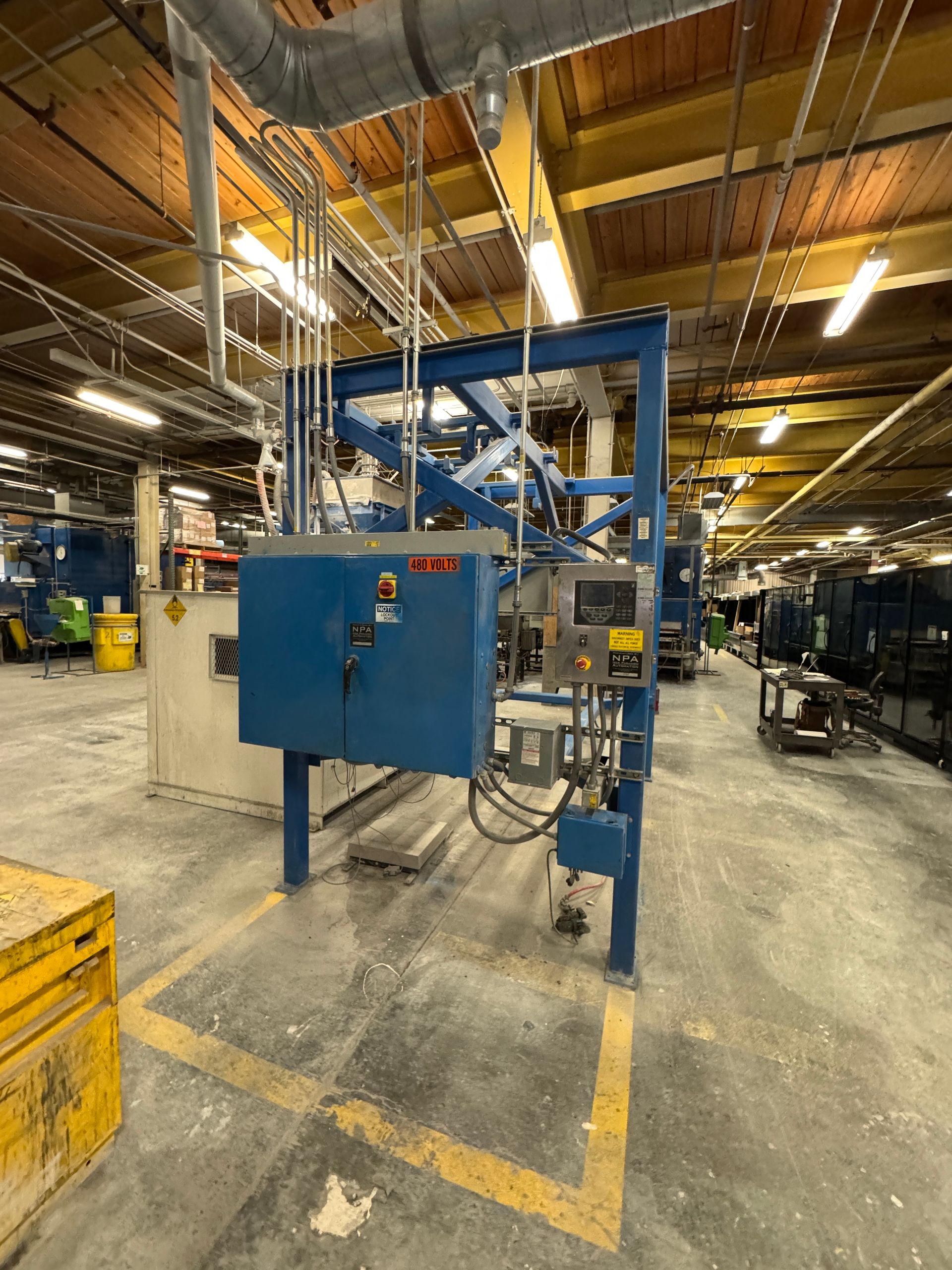 Blue industrial machine in a factory setting.
