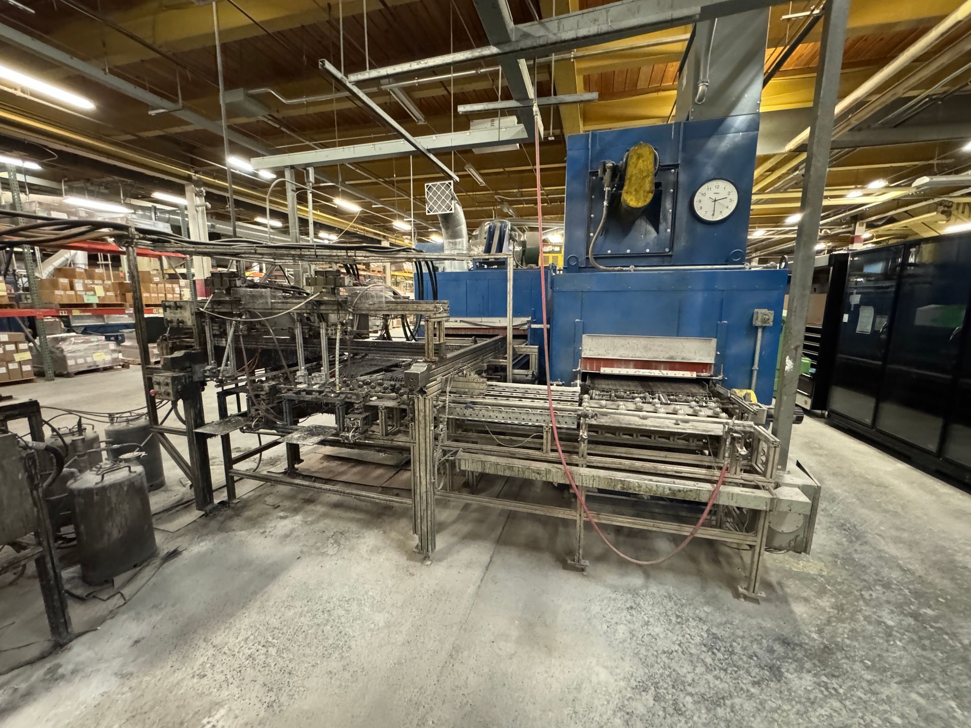 Industrial oven in a factory setting. Blue oven with conveyor system.