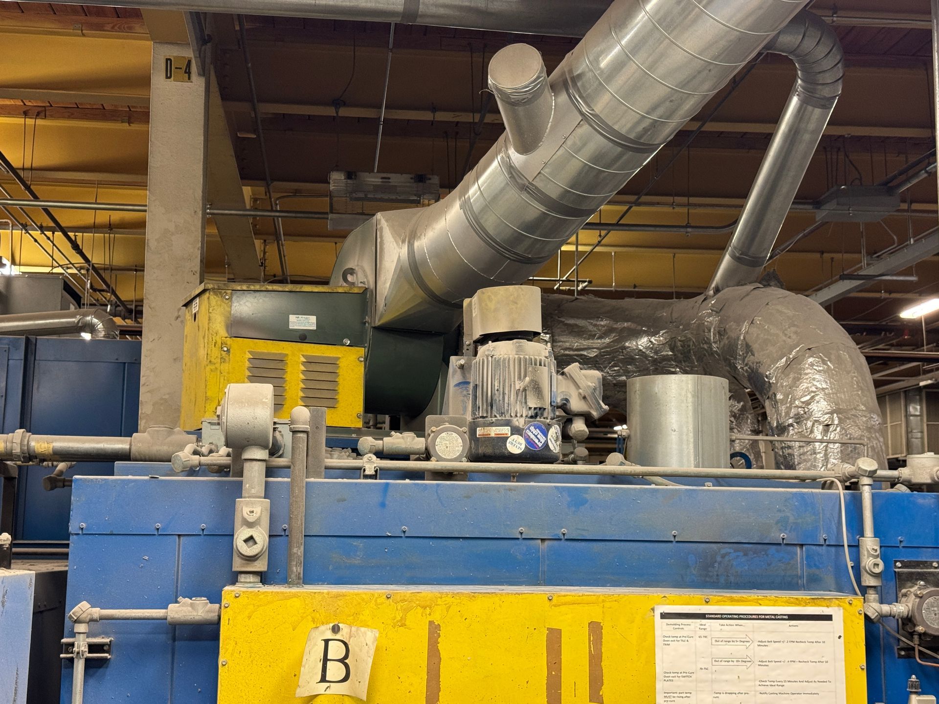 Blue and yellow industrial machinery with large silver ductwork.