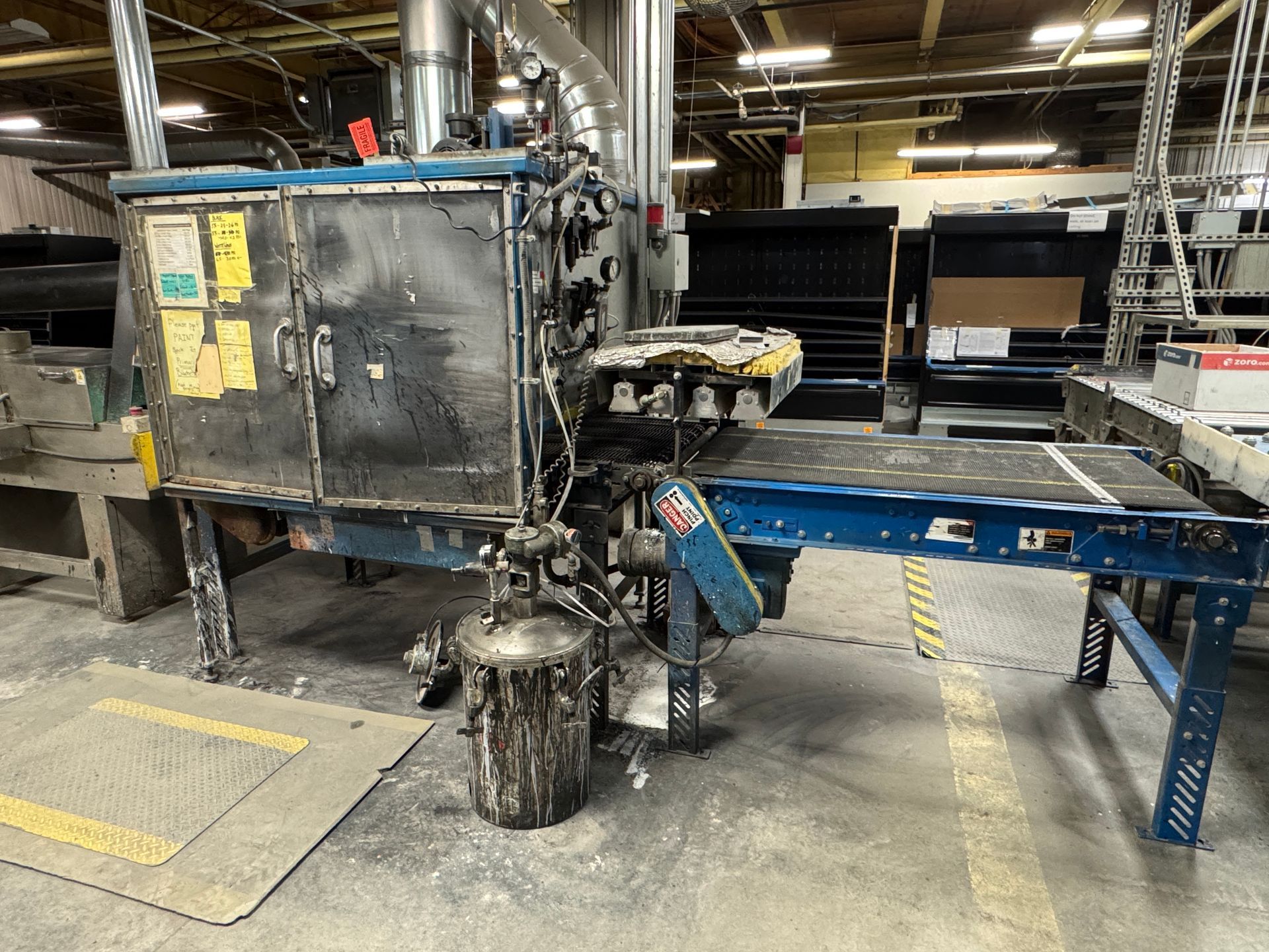 Industrial machine with conveyor, in a factory setting.