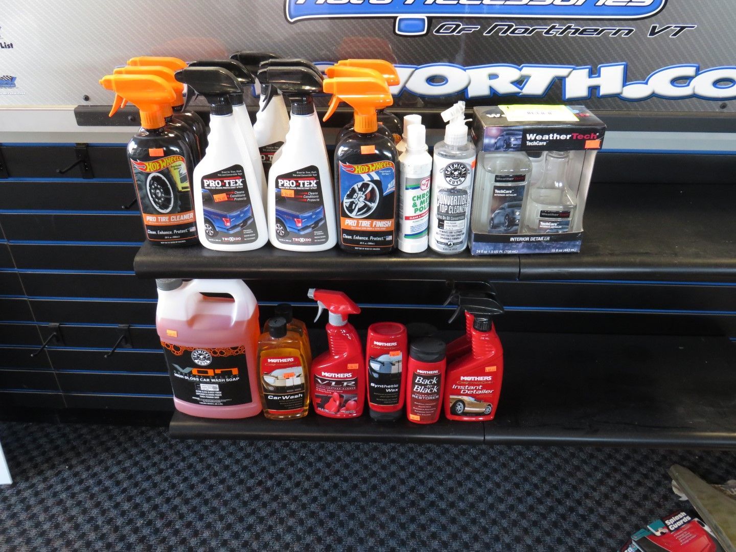 Shelves stocked with various car cleaning products in a store setting.