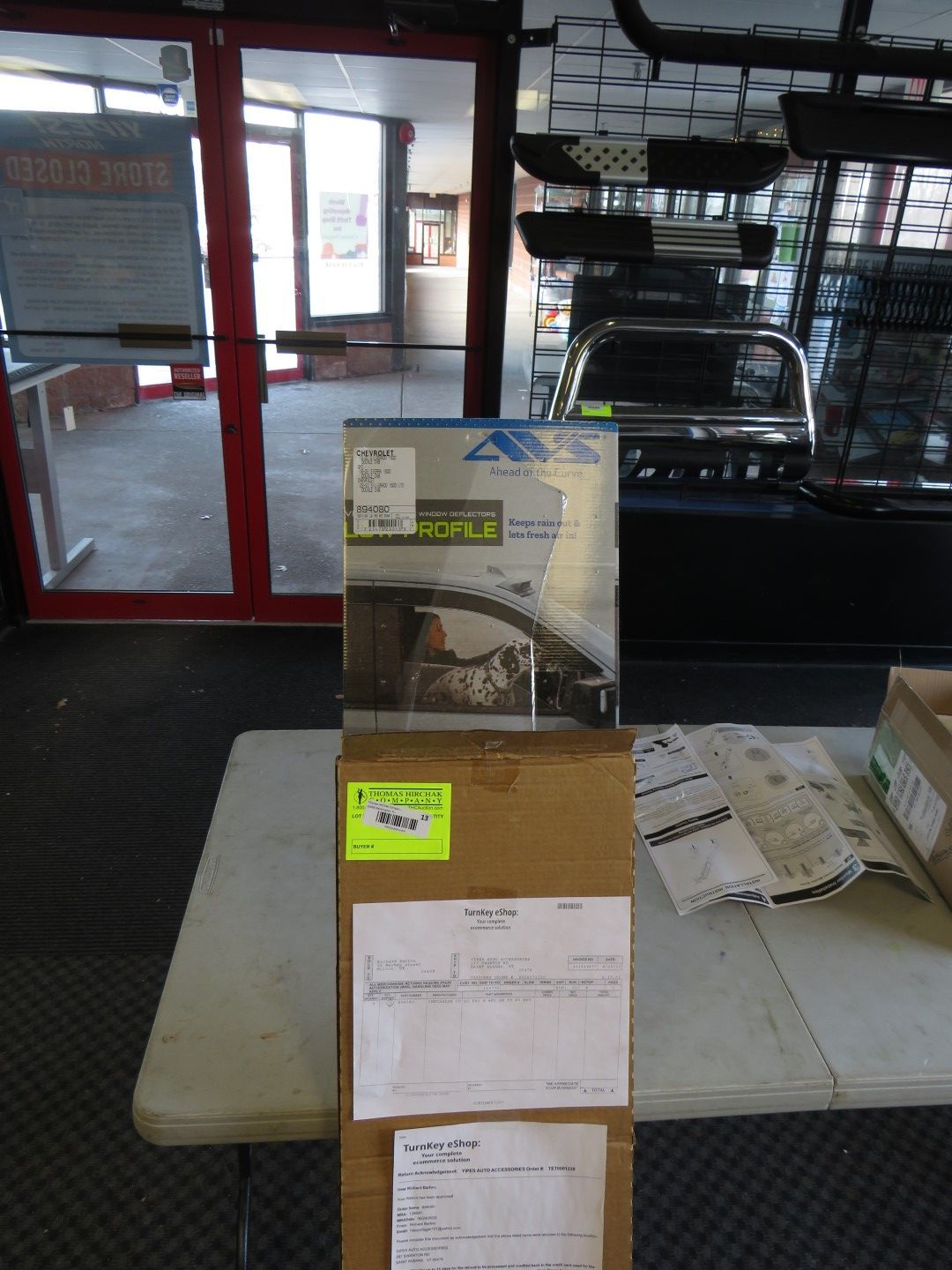 Boxes stacked on a table in a store. One box has a product brochure on top.