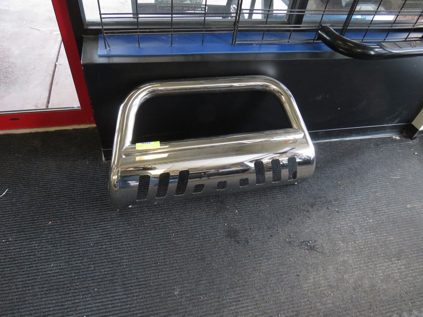 Chrome bull bar bumper on display indoors.