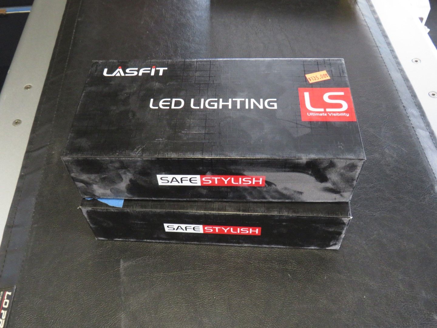 Two black Lasfit LED lighting boxes stacked on a dark surface.