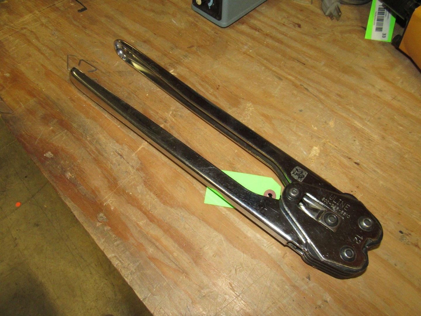 Steel banding tool on a wooden surface.