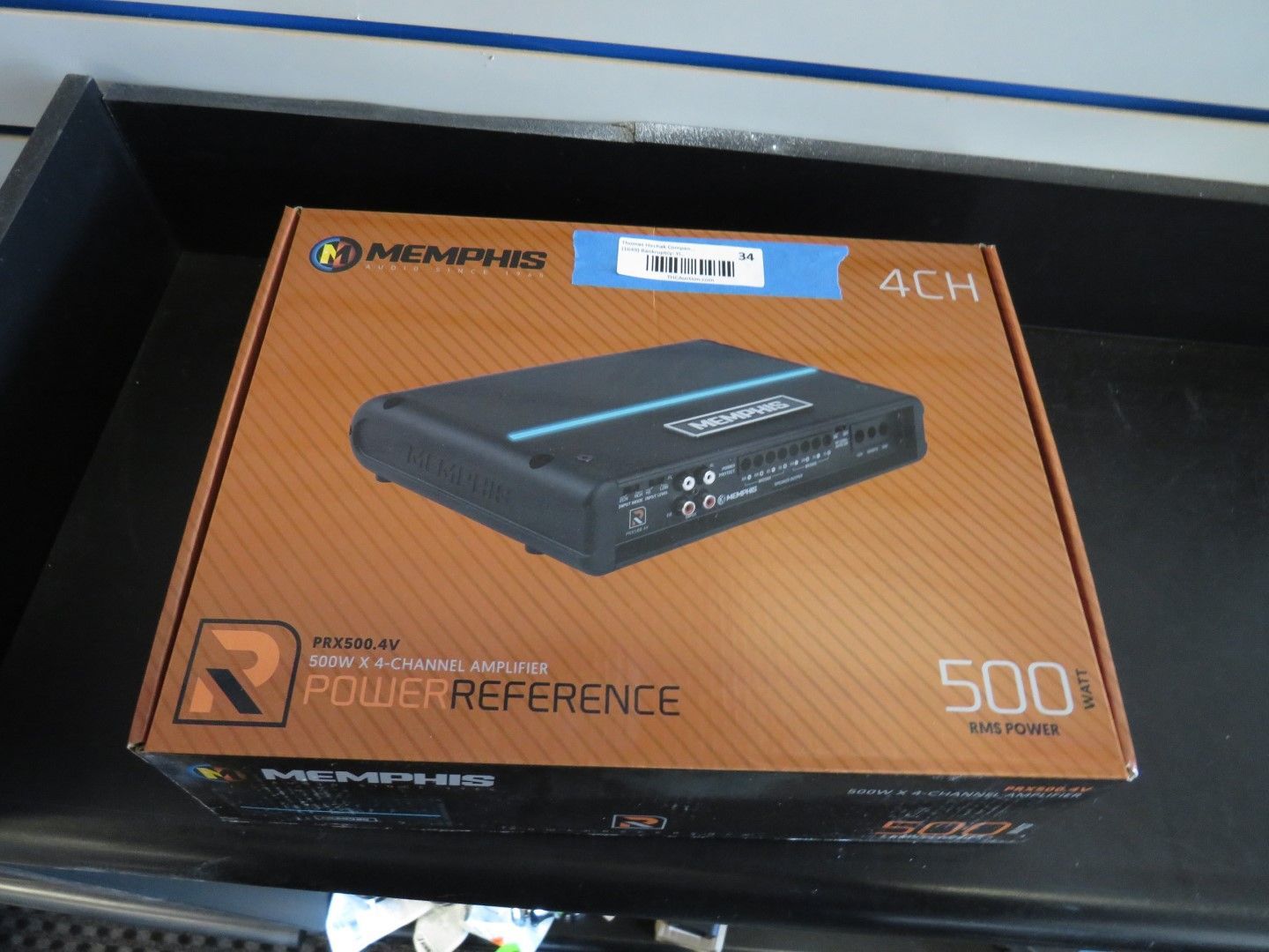Box of a Memphis Power Reference 500.4 amplifier, in a black drawer.