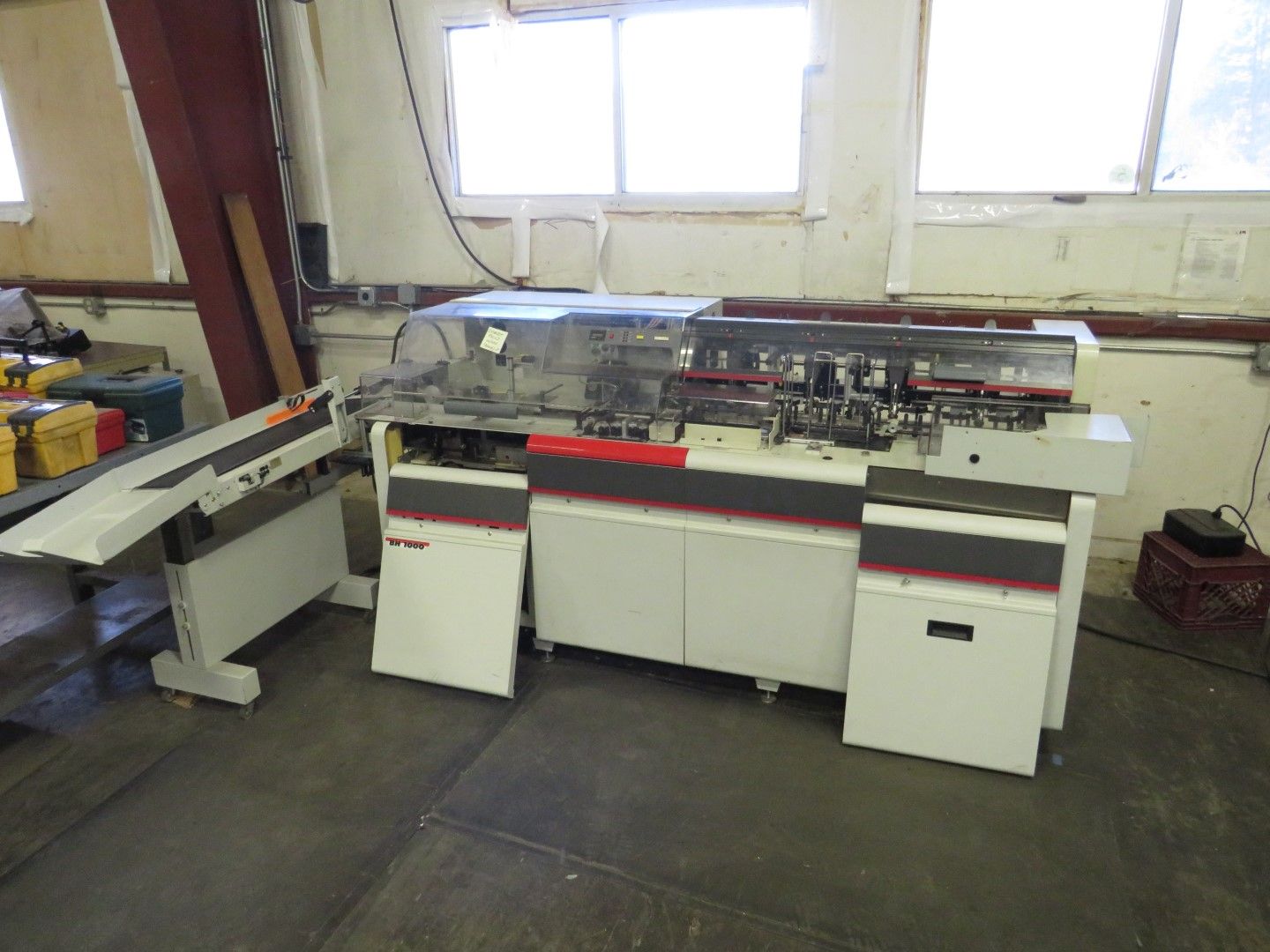 White and gray industrial machine with red accents, in a workshop setting.