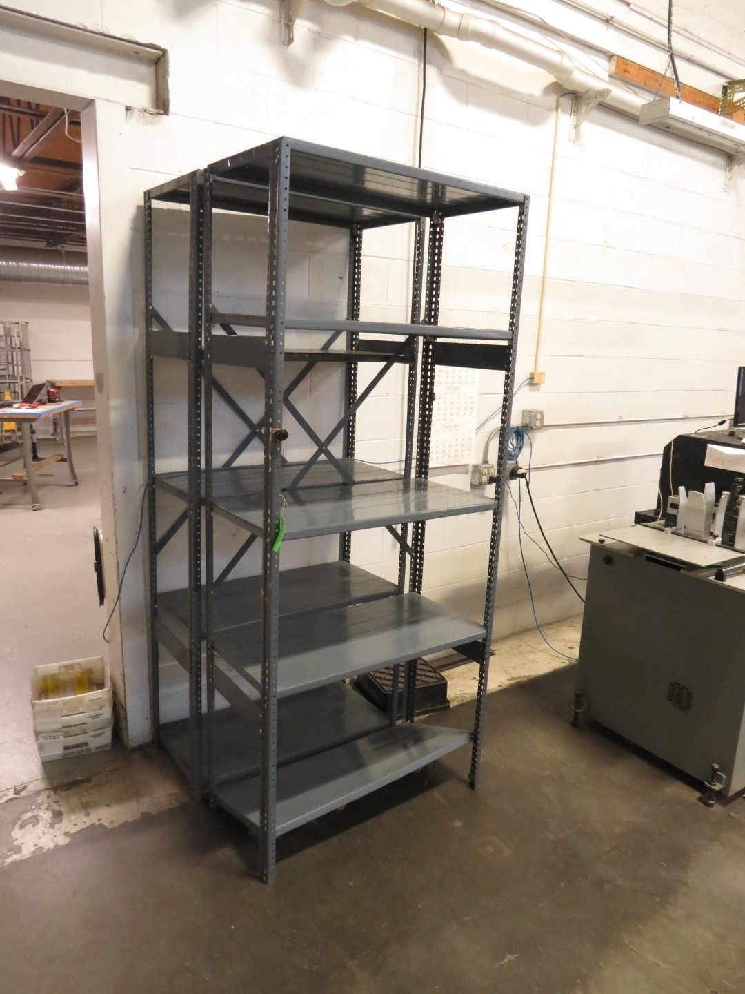 Gray metal shelving unit in an industrial setting.