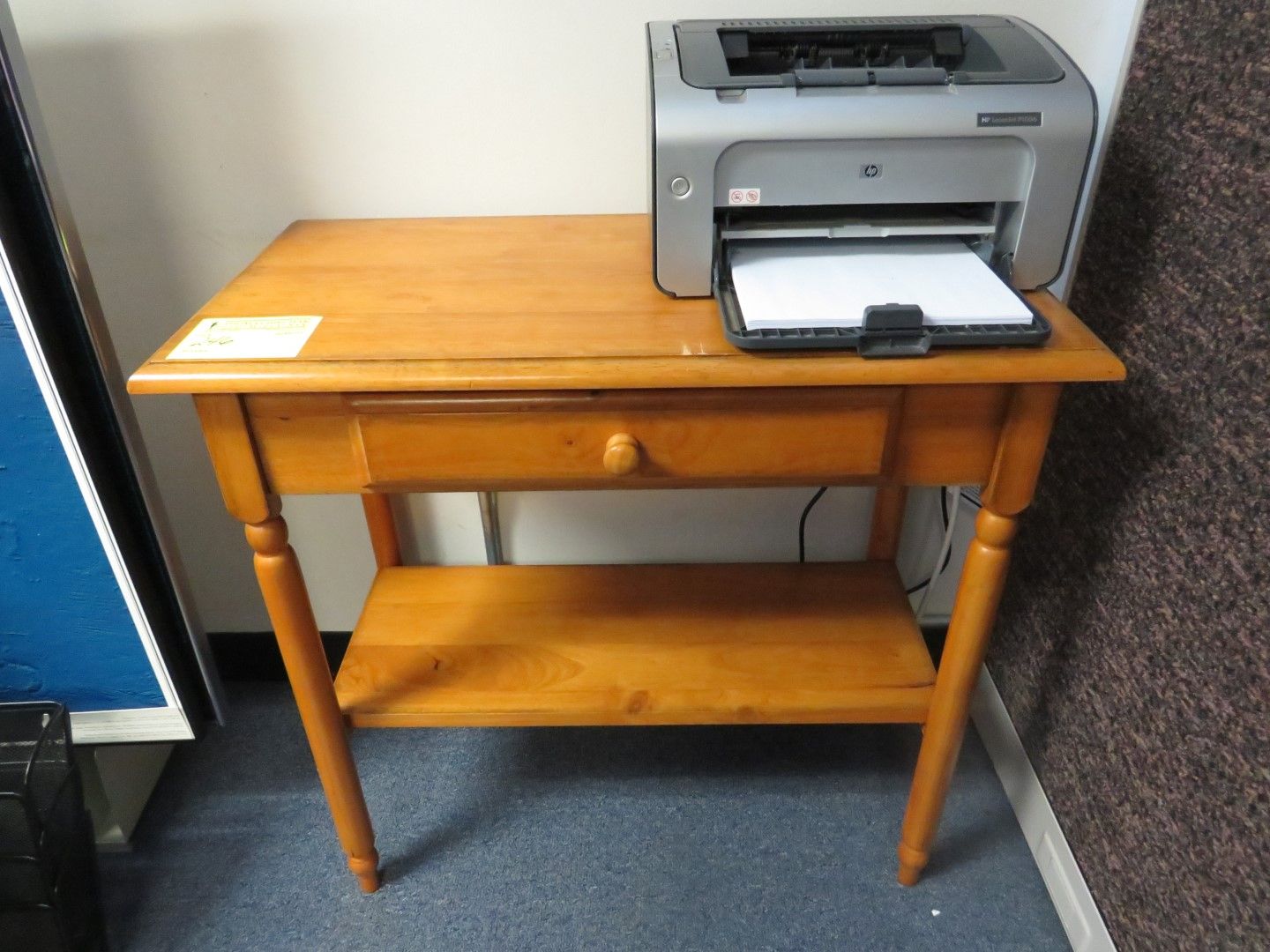 Wooden side table with a printer on top and a drawer.