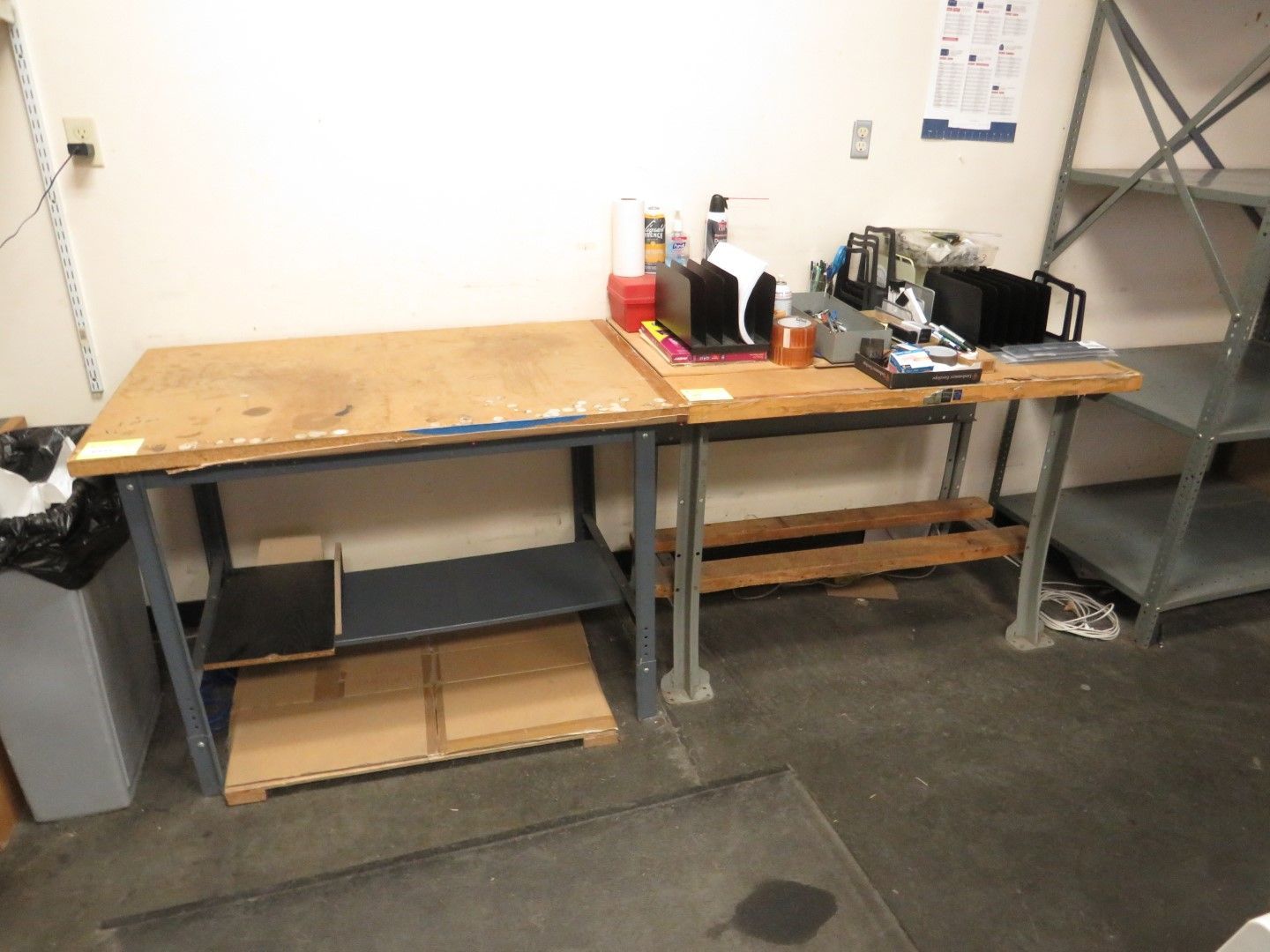 A workbench with tools and supplies, near metal shelving in a workshop.