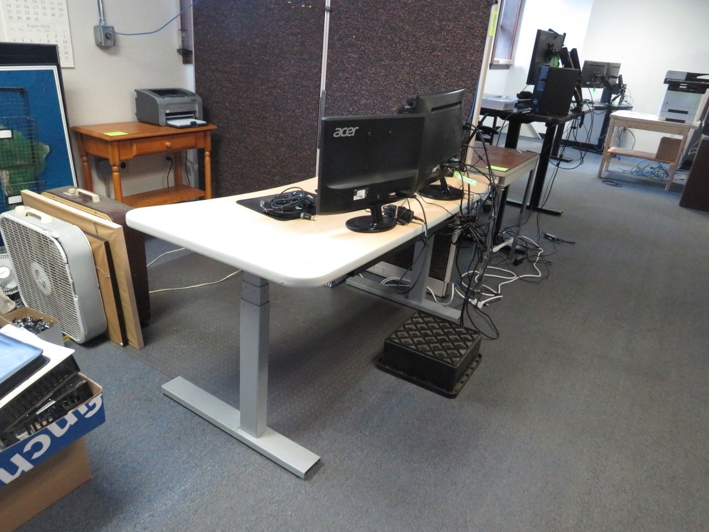 A desk with two monitors and a keyboard in an office setting.