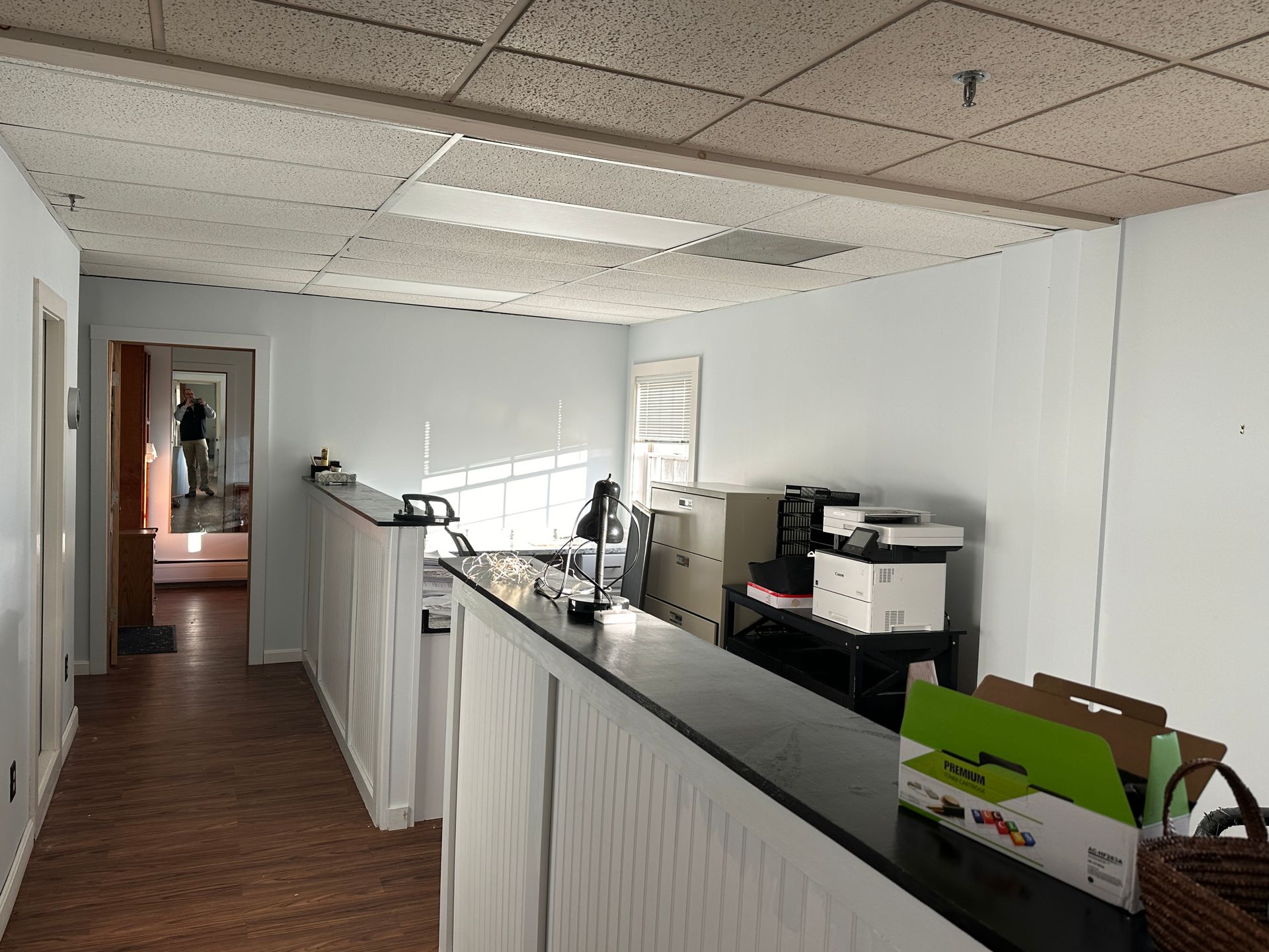 Interior shot of a reception area with a long counter and equipment. A hallway leads to other rooms.