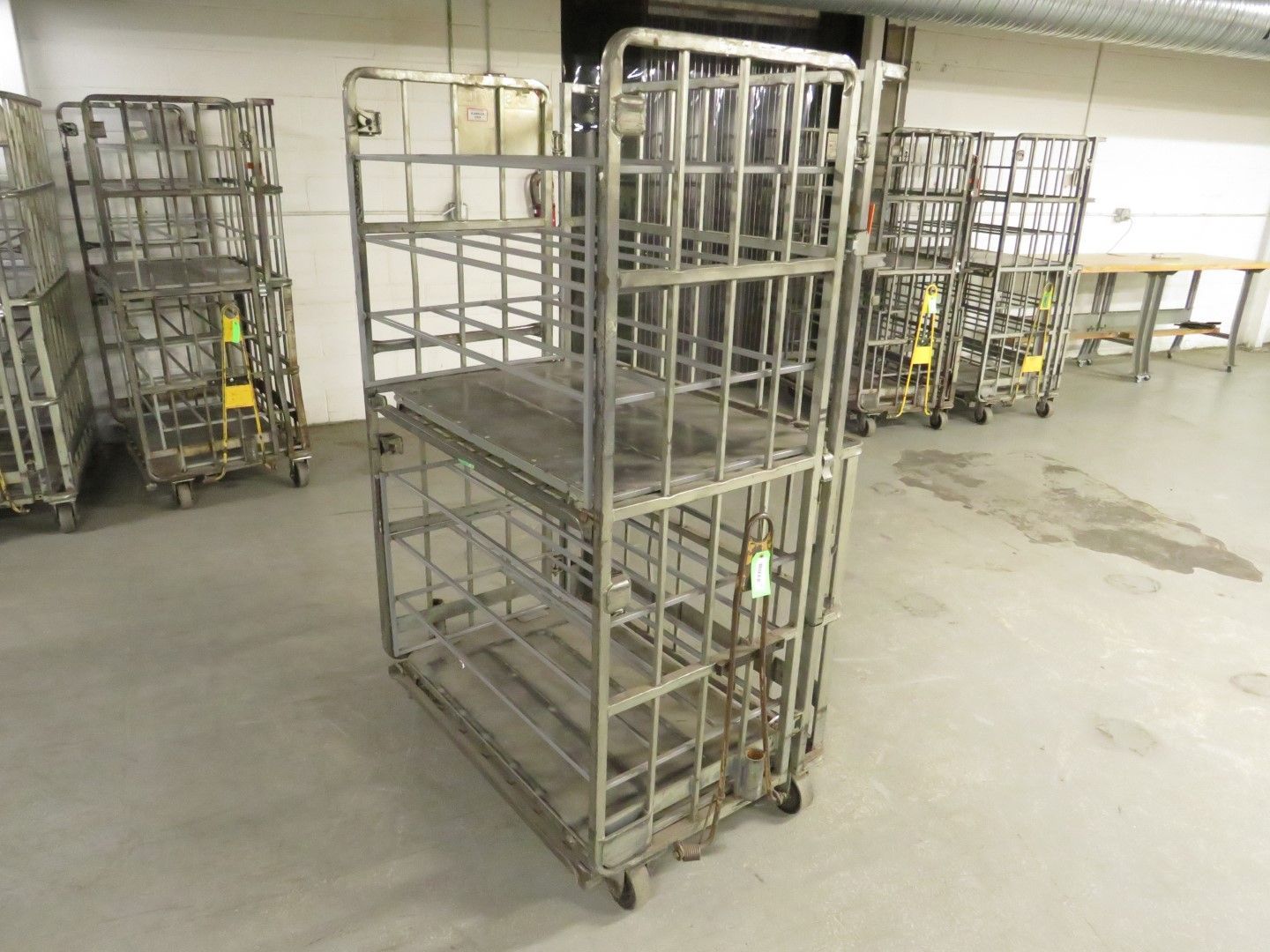 Metal storage carts on wheels in a warehouse setting.