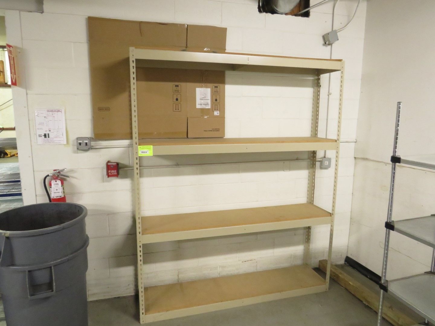 Metal shelving unit in a storage area, holding cardboard boxes.
