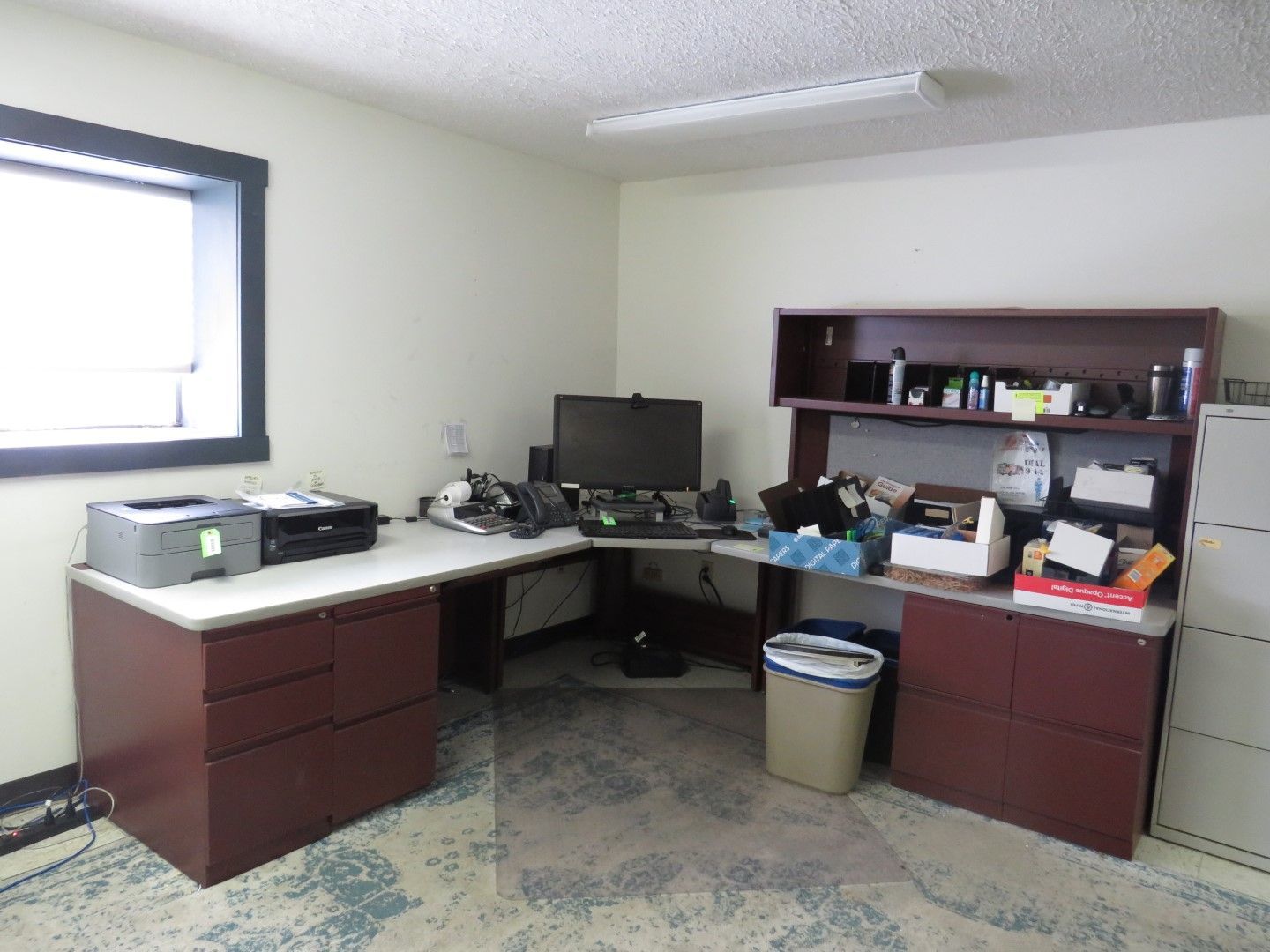 Office with a corner desk, printer, and storage.