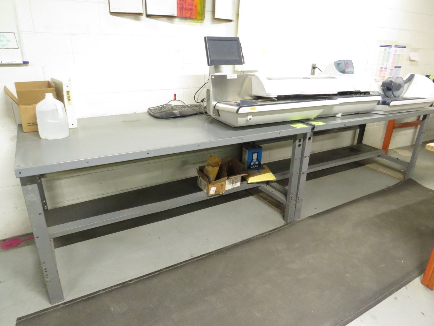 Metal workbench with equipment, shelves, and supplies in a room.
