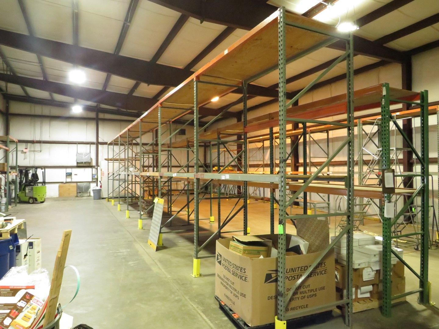 Warehouse interior with tall empty metal shelving. Cardboard boxes sit near the shelving.