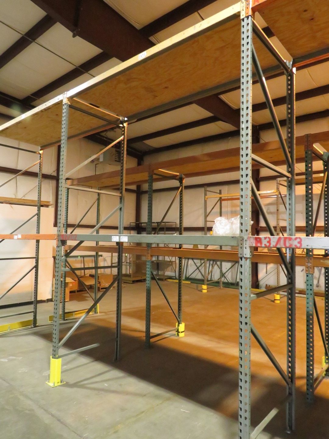Warehouse with metal shelving, plywood floor.