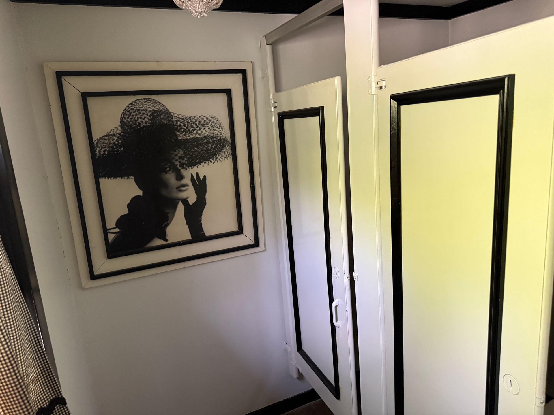Hallway with framed black-and-white portrait and white doors outlined in black trim