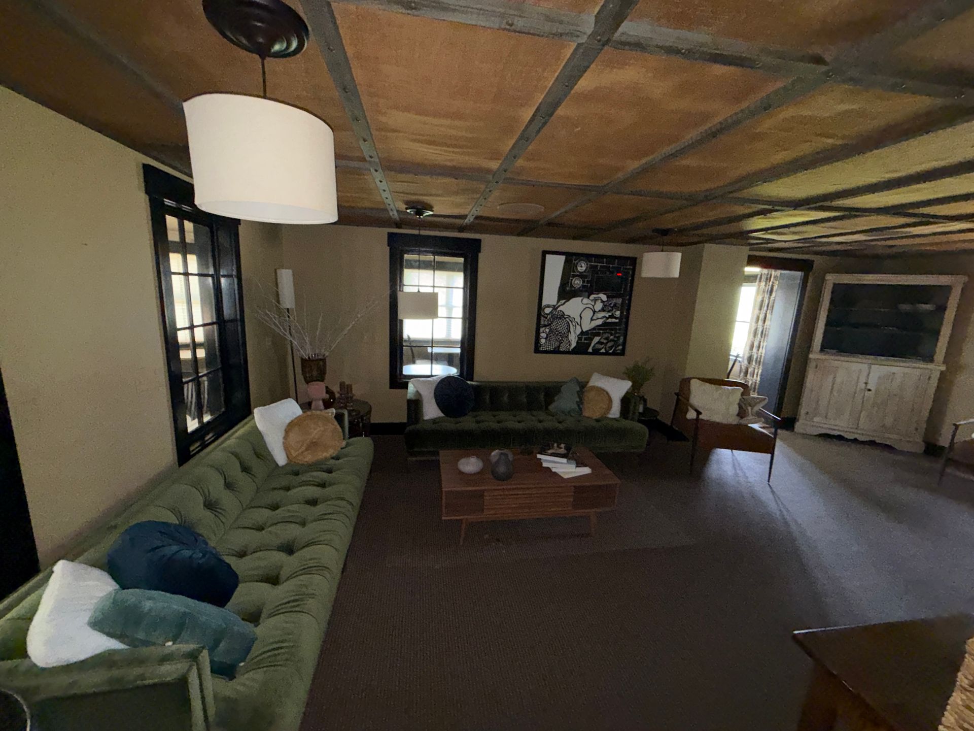 Modern living room with green sectional, coffee table, floor lamp, and a piano by the wall