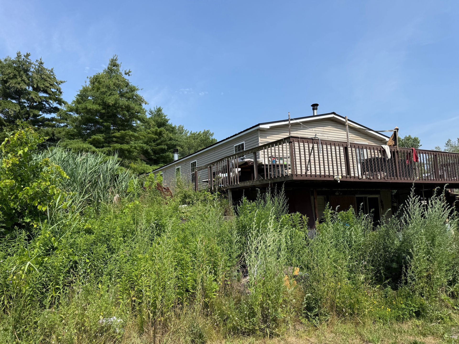 hillside with a wooden decked house under a blue sky