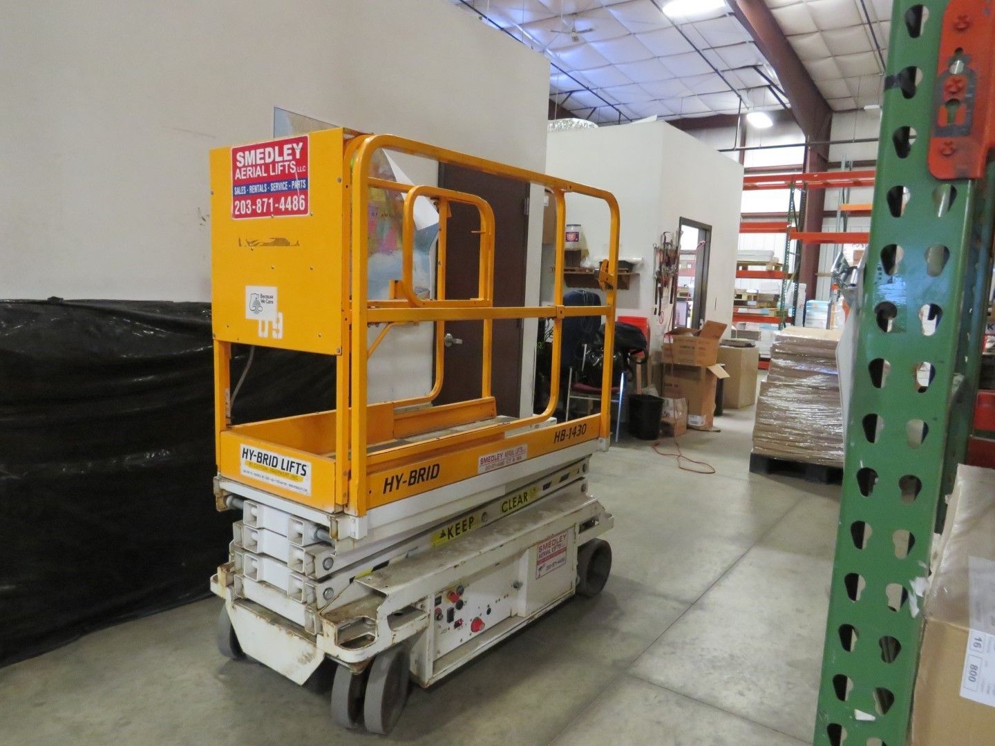 Yellow scissor lift in a warehouse.