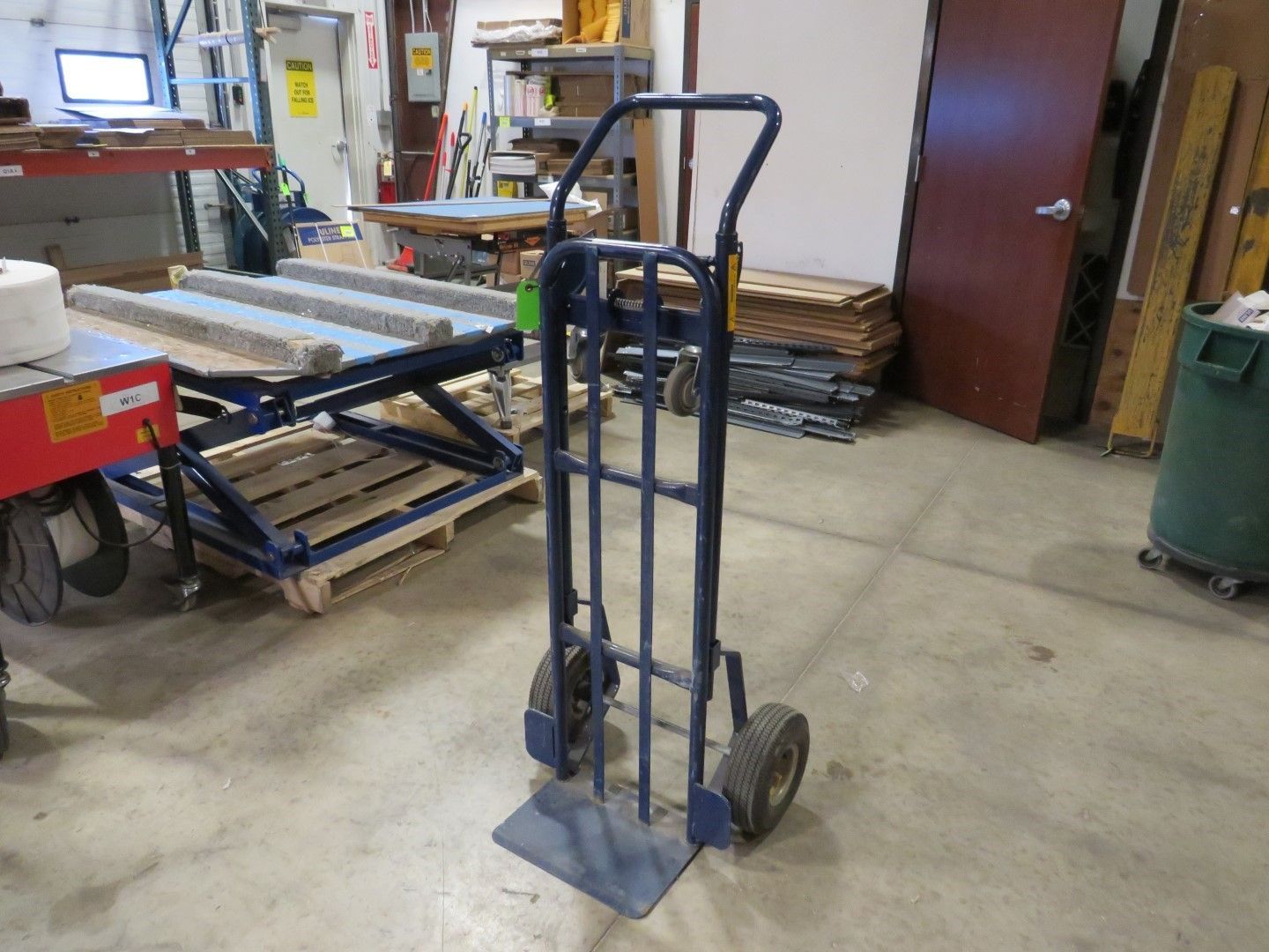 Blue hand truck in a warehouse.