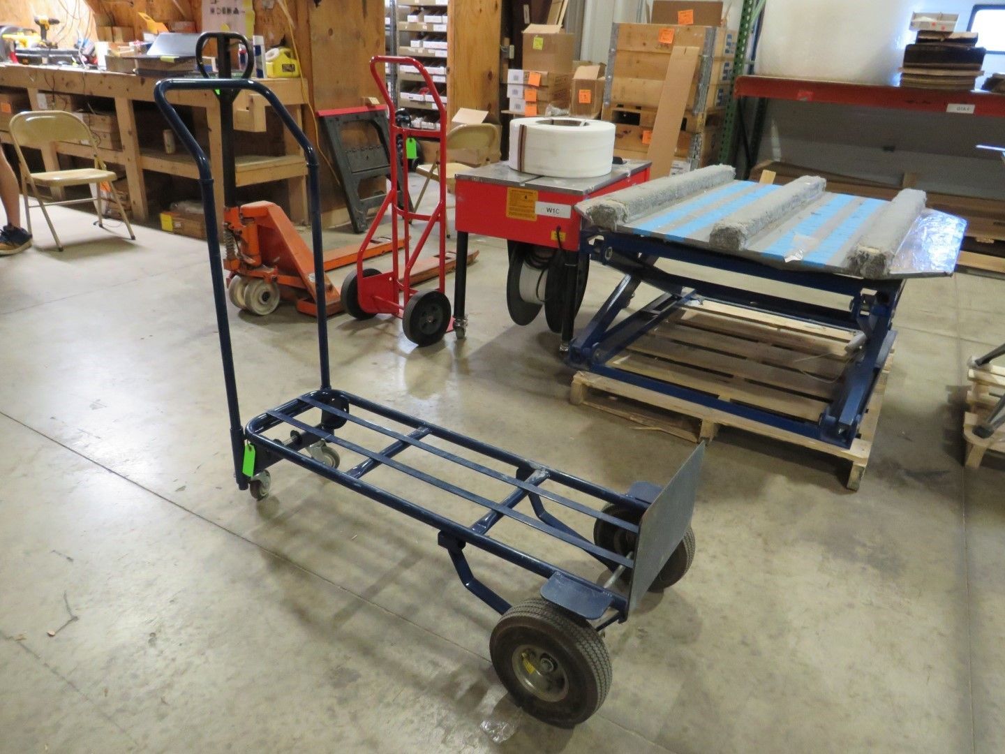 Blue metal cart with pneumatic tires, plus other material handling equipment, indoors.