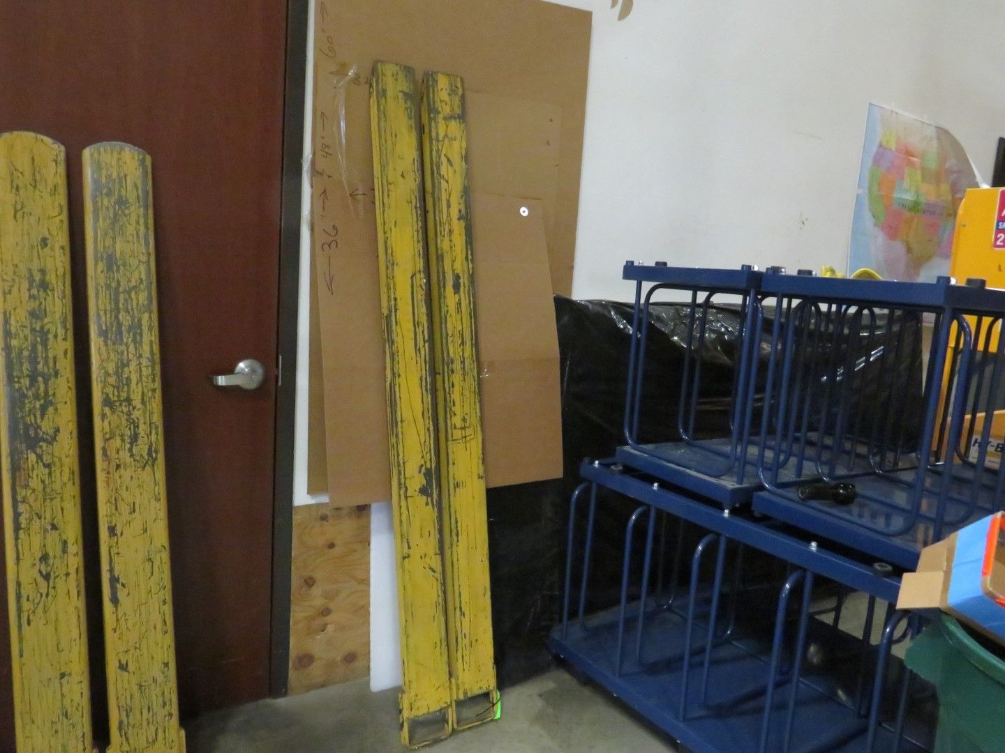Yellow painted planks, brown door and cardboard in a room.