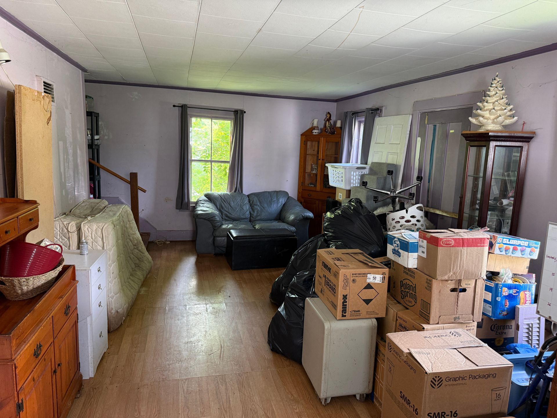 living room with boxes and storage items, a couch by a window
