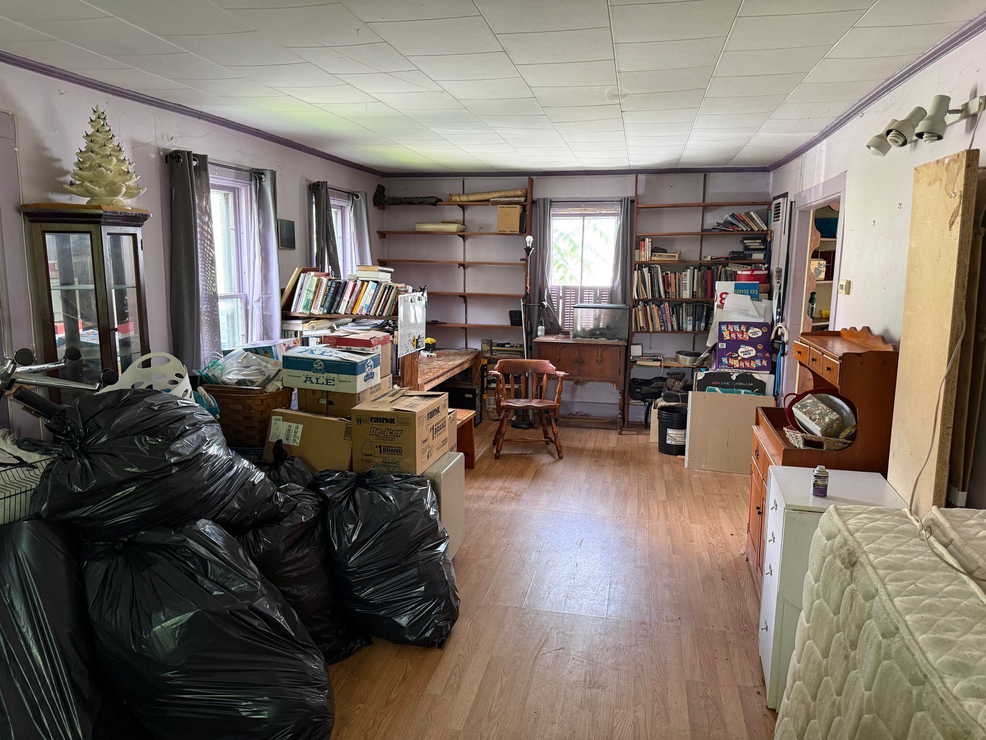 room with boxes, shelves, a desk, and a small window on the back wall.
