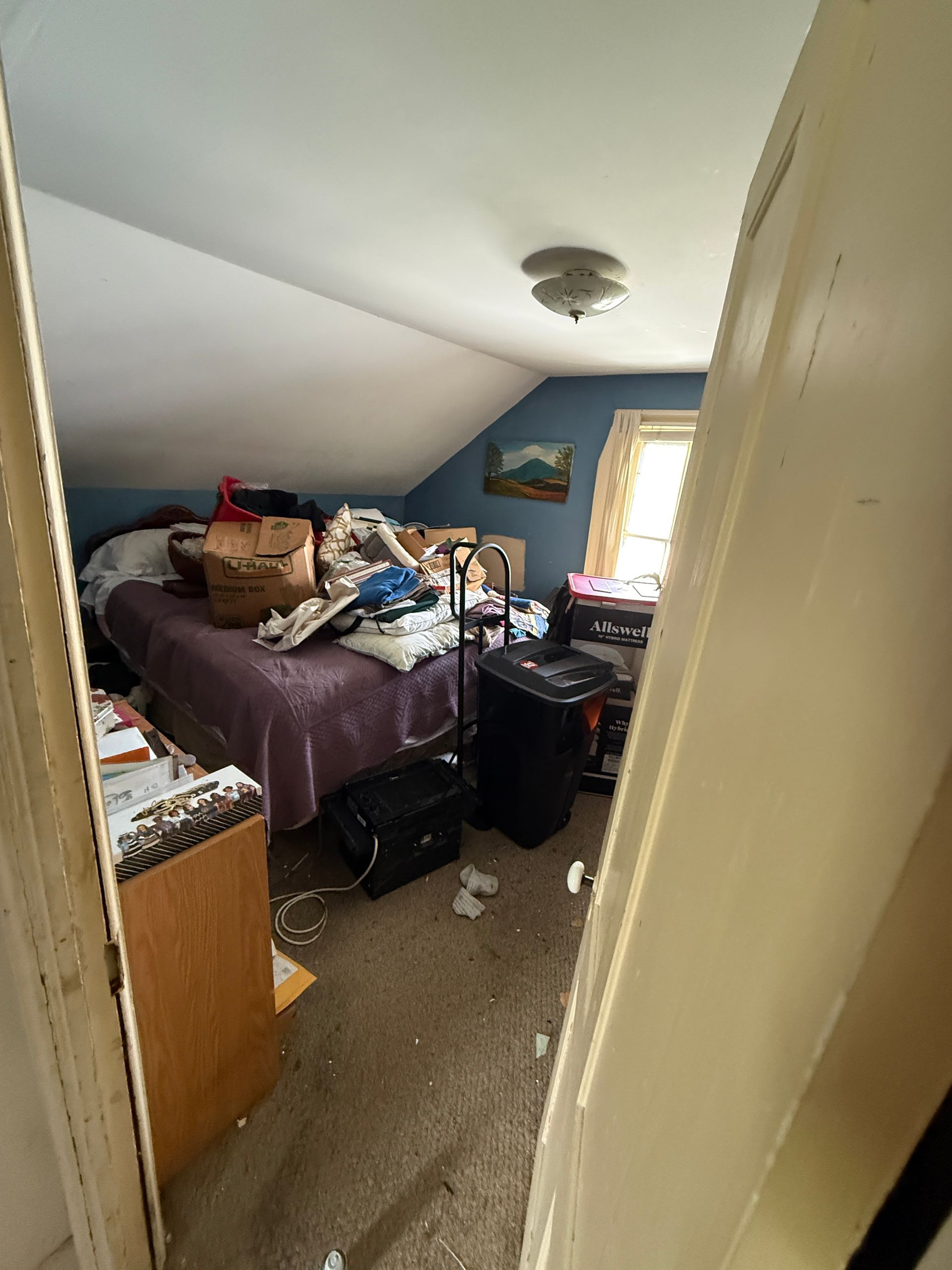 bedroom with a bed and a window letting in daylight.