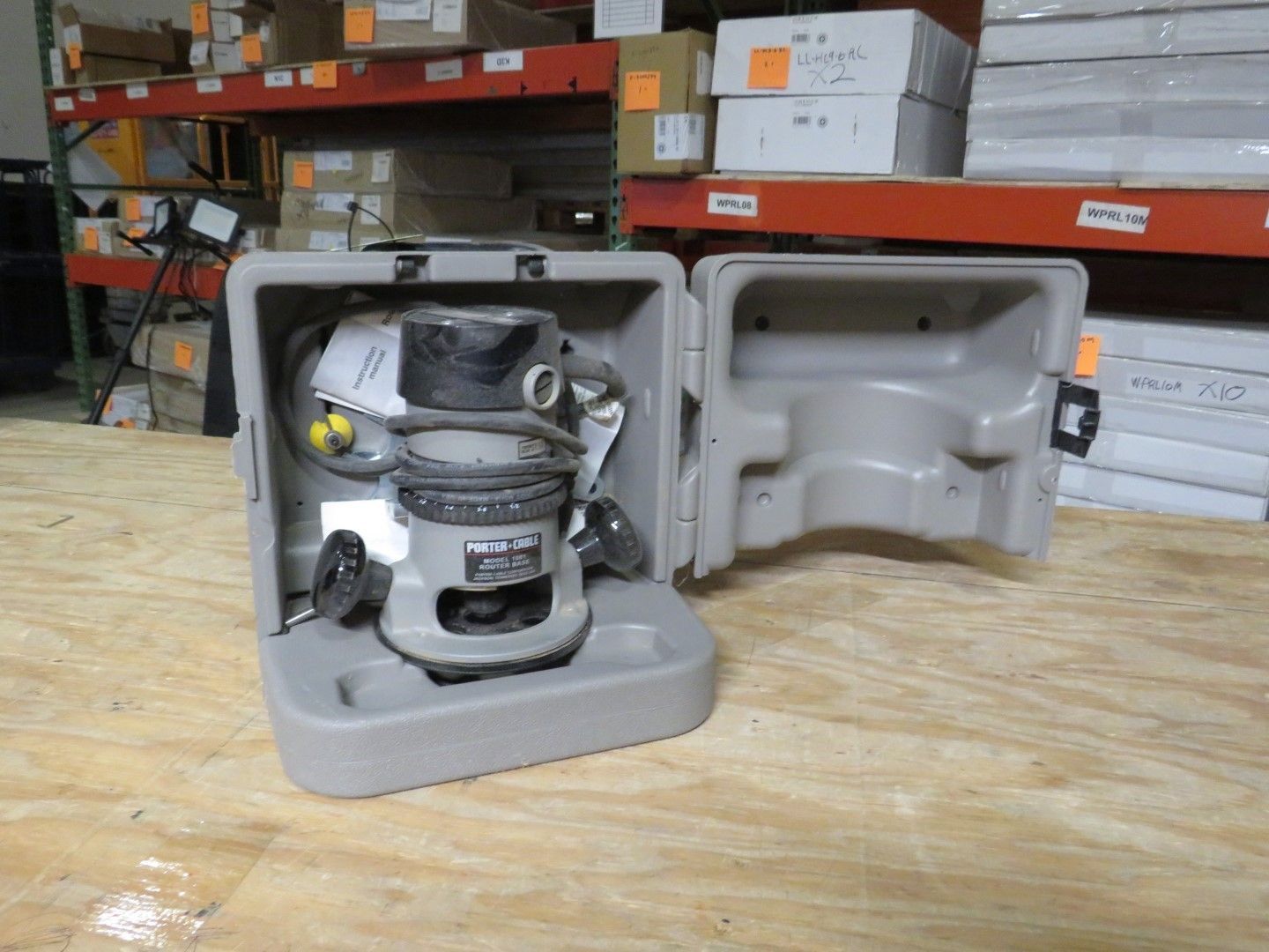 Surveying instrument inside a gray case, set on a wooden surface.