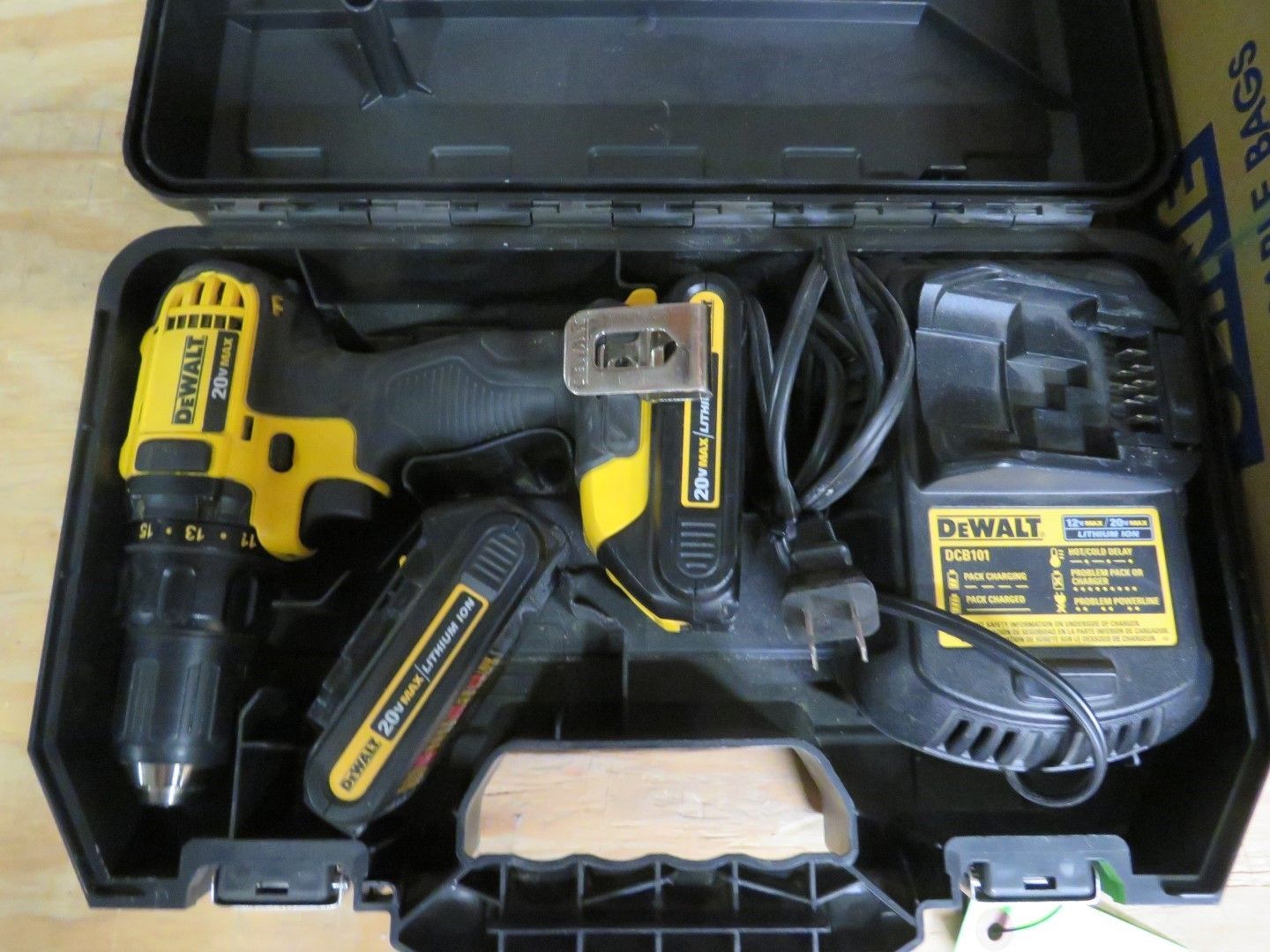 DeWalt cordless drill and accessories in a black case: drill, battery charger, and two batteries.