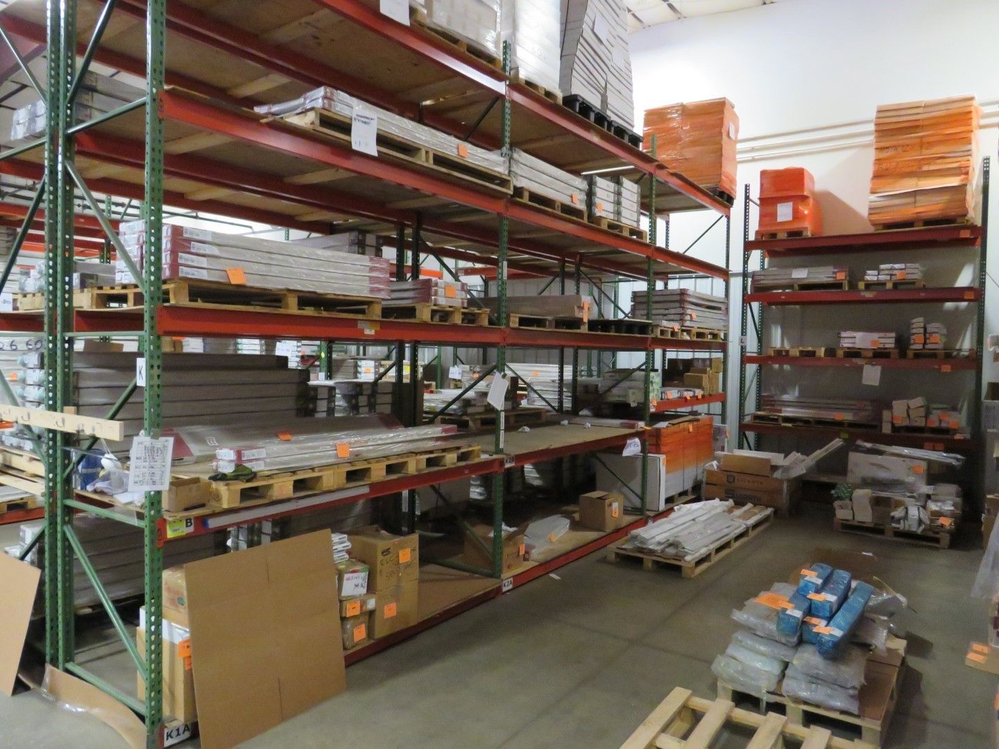 Warehouse shelving filled with building materials on pallets.