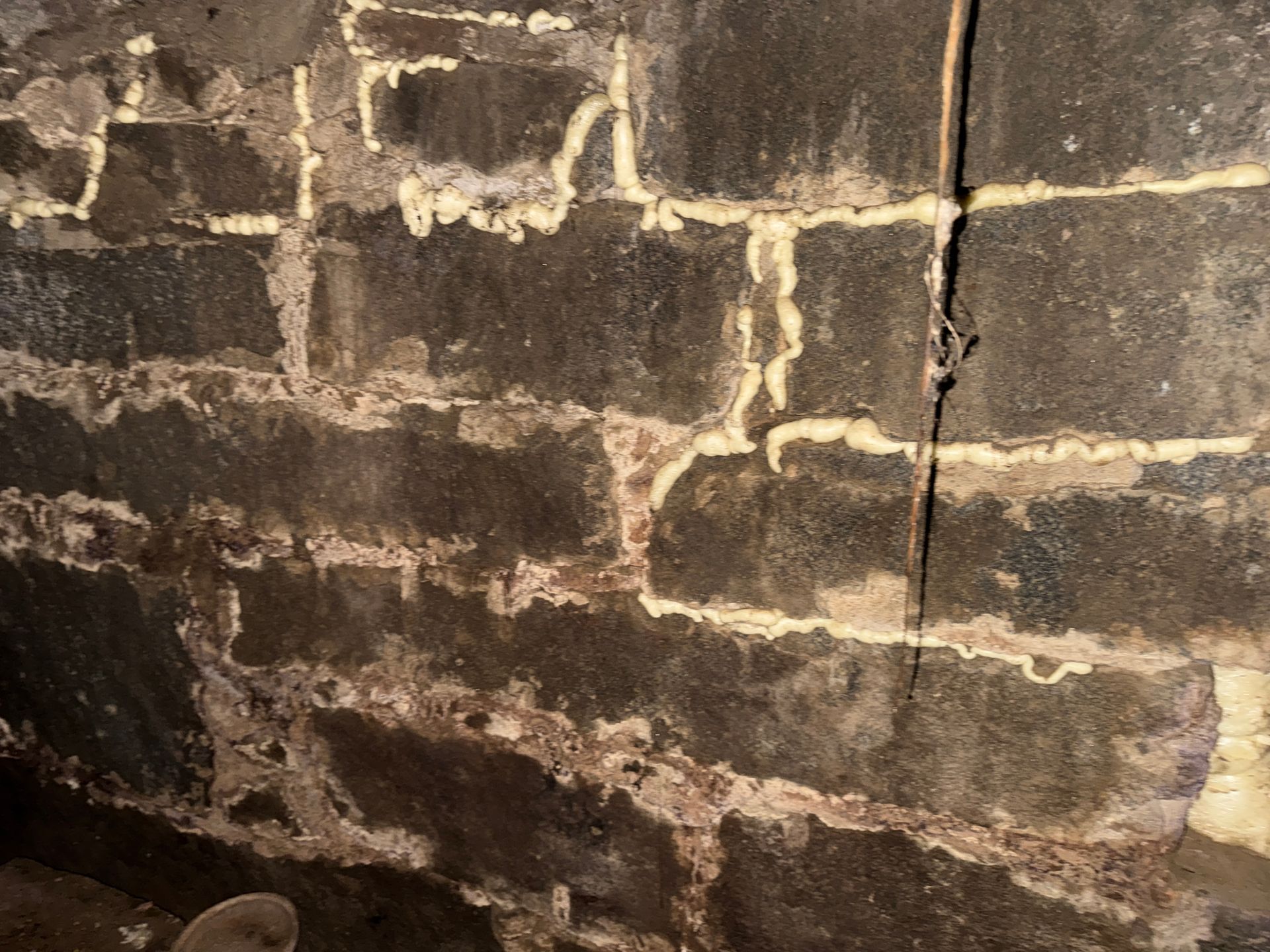 Old brick wall with peeling dark paint