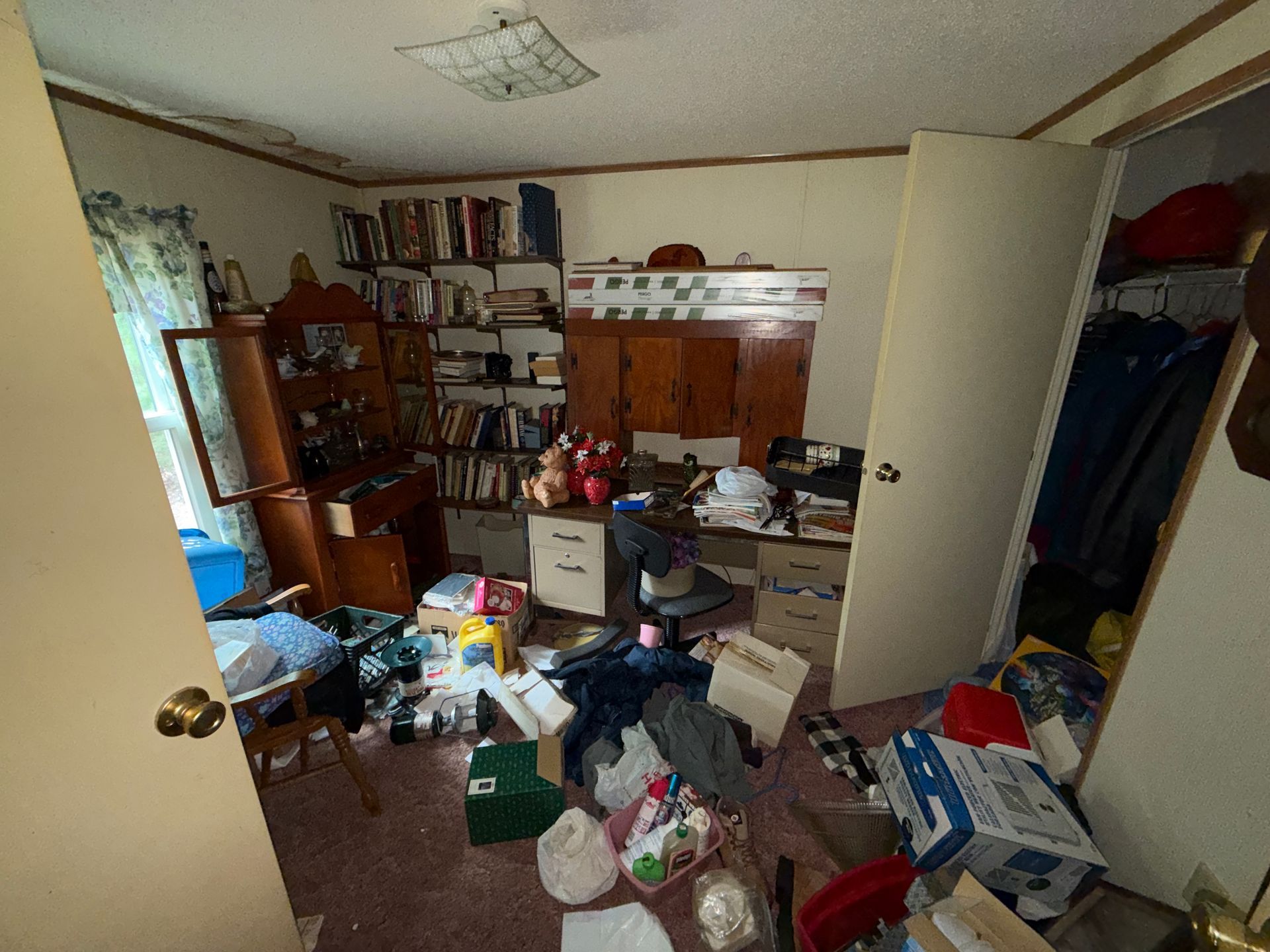bedroom with clothes, boxes, and papers