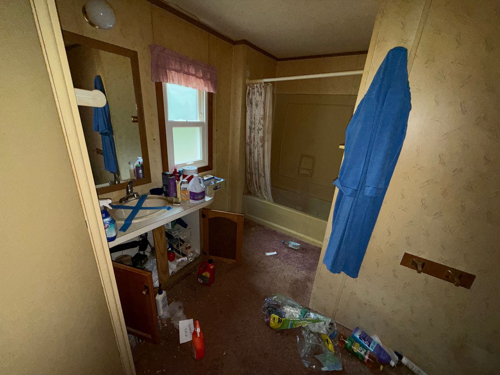 bathroom with blue towel on the wall, sink by a window