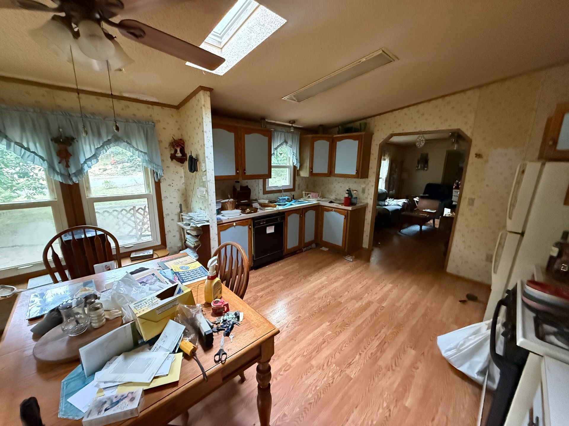 kitchen with wooden cabinets, dining table, sink, and refrigerator in a small home interior