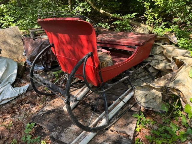 Red horse-drawn sleigh with black metal runners